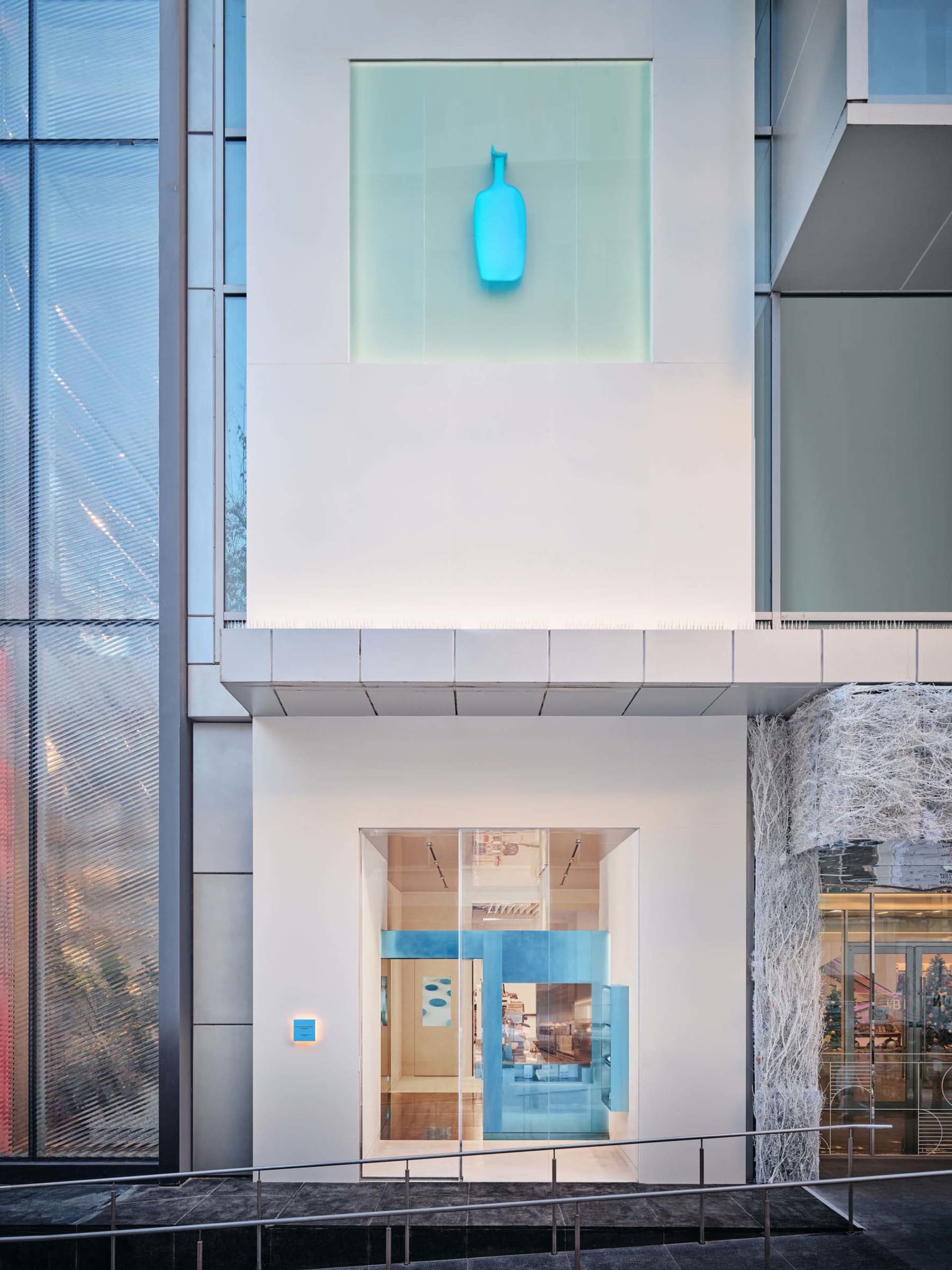Modern commercial building with glass facade and blue lighting feature