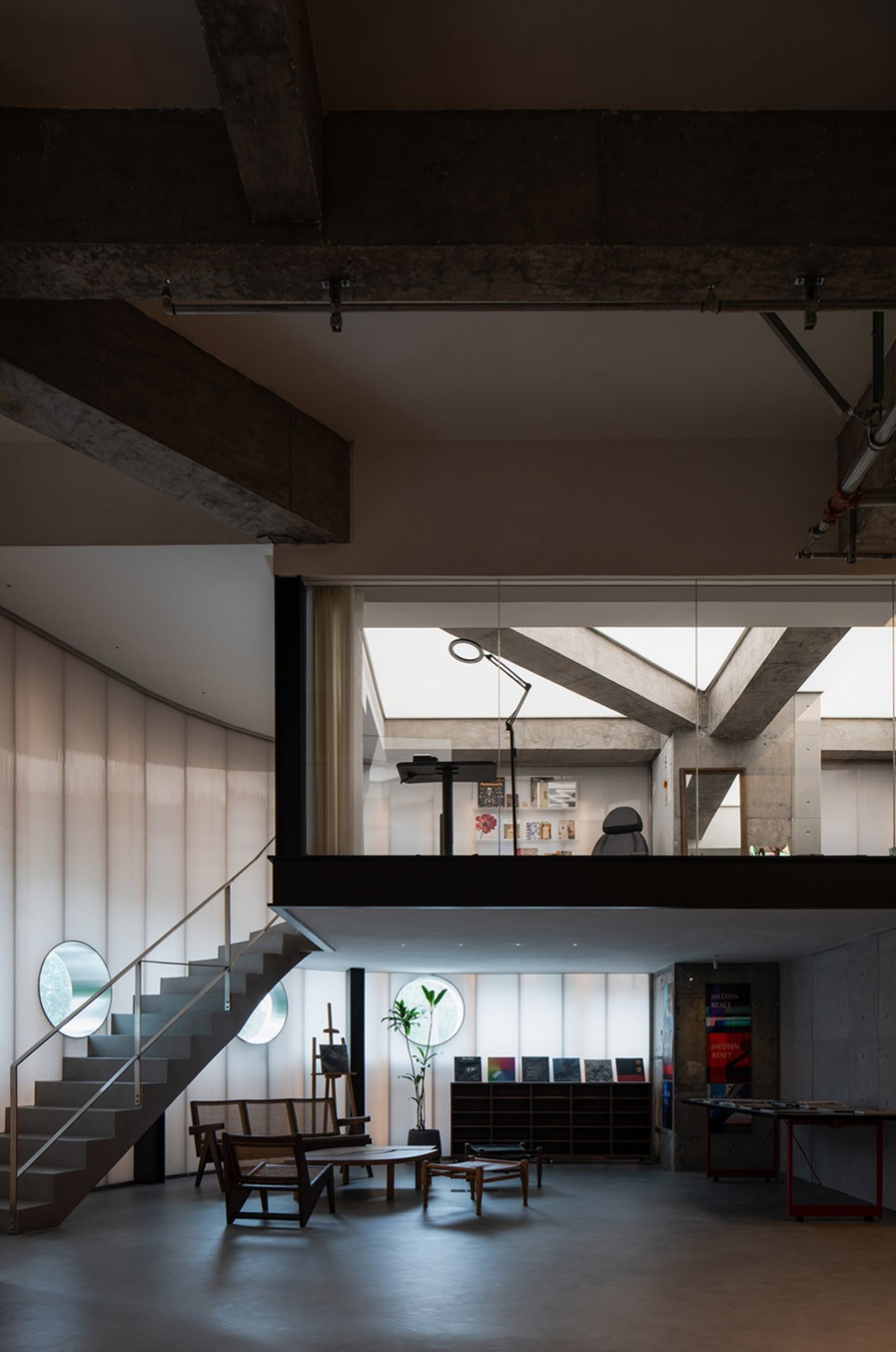 Modern, industrial-style living room featuring exposed concrete beams and natural light.