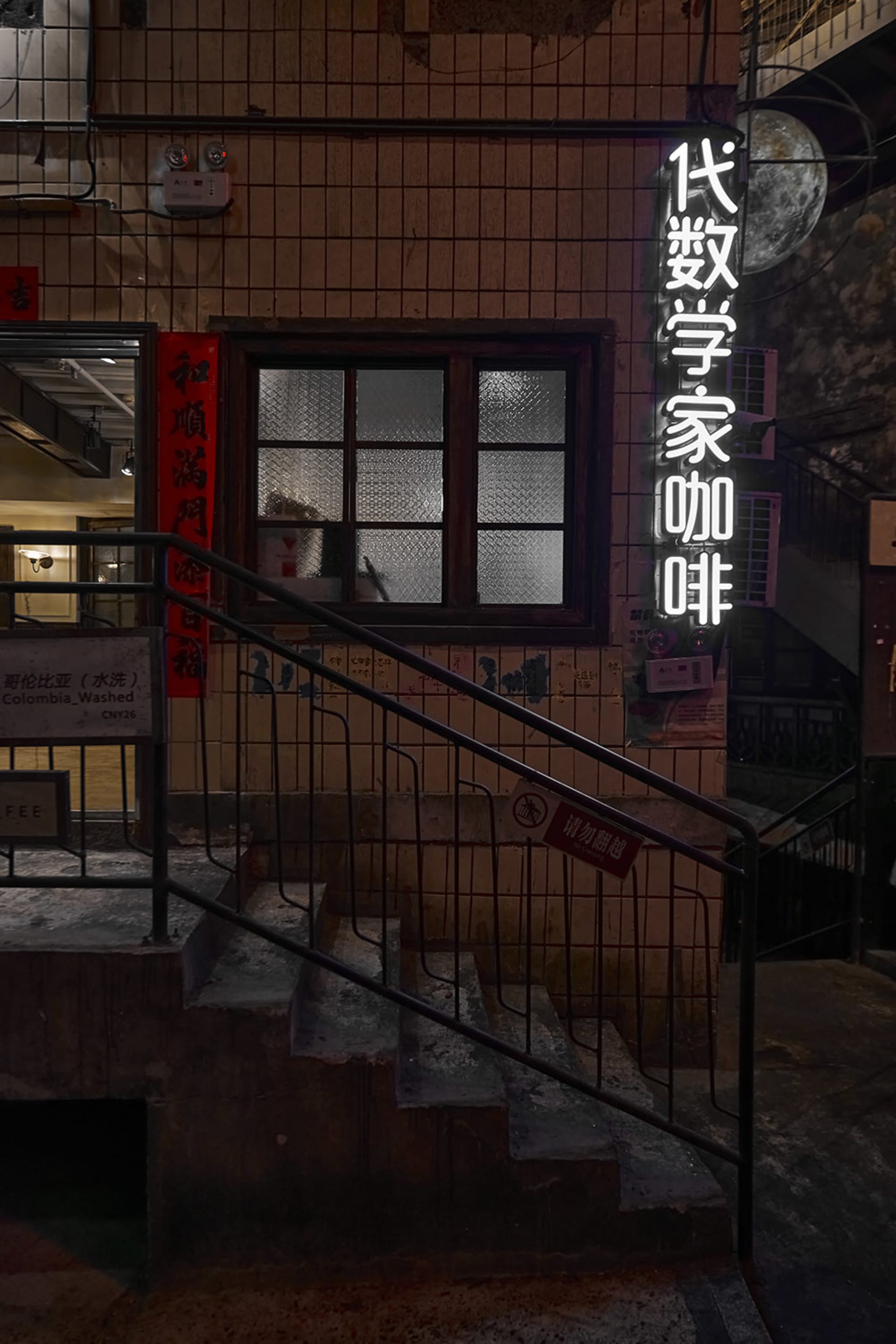 混凝土樓梯在夜間都市環境中被霓虹燈招牌照亮