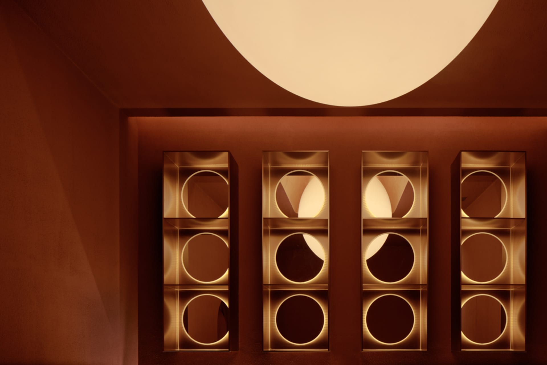 A minimalist modern interior messaging system with illuminated round panels on a metallic surface.