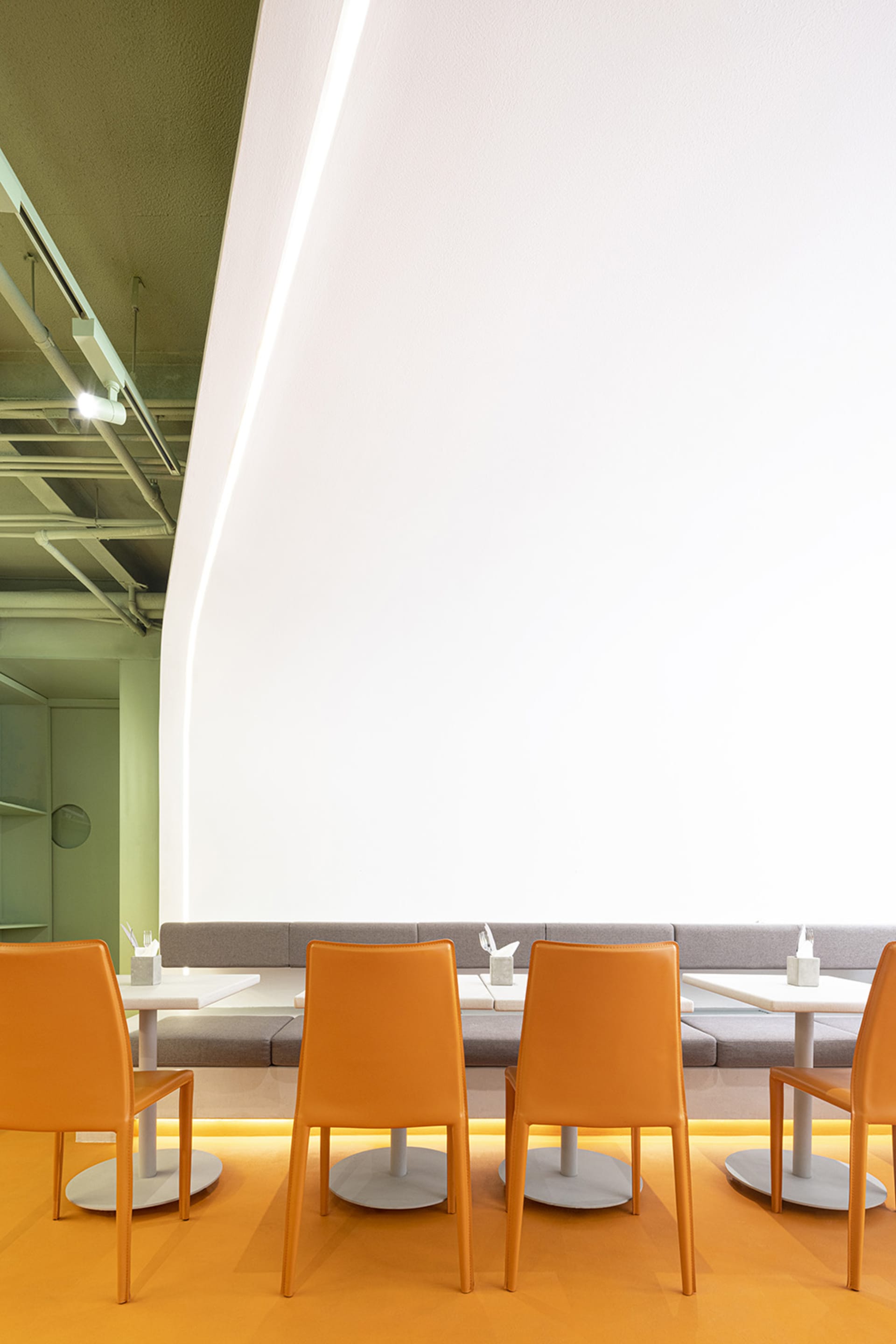 Modern restaurant cafe seating area with orange leather chairs and metal legs