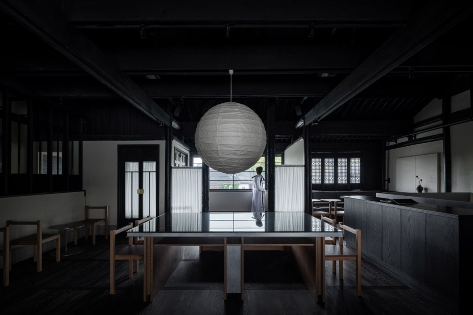 當代餐廳室內空間,搭配深色木質家具與大型球形燈具。