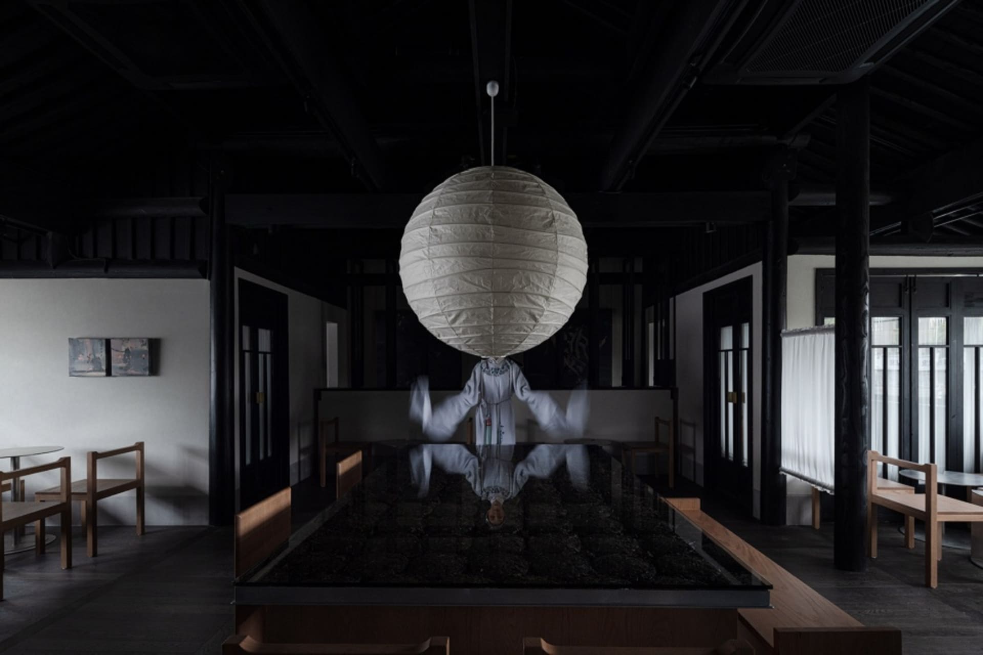 現代餐廳室內空間，懸掛圓形紙燈、木質家具與玻璃吧台。