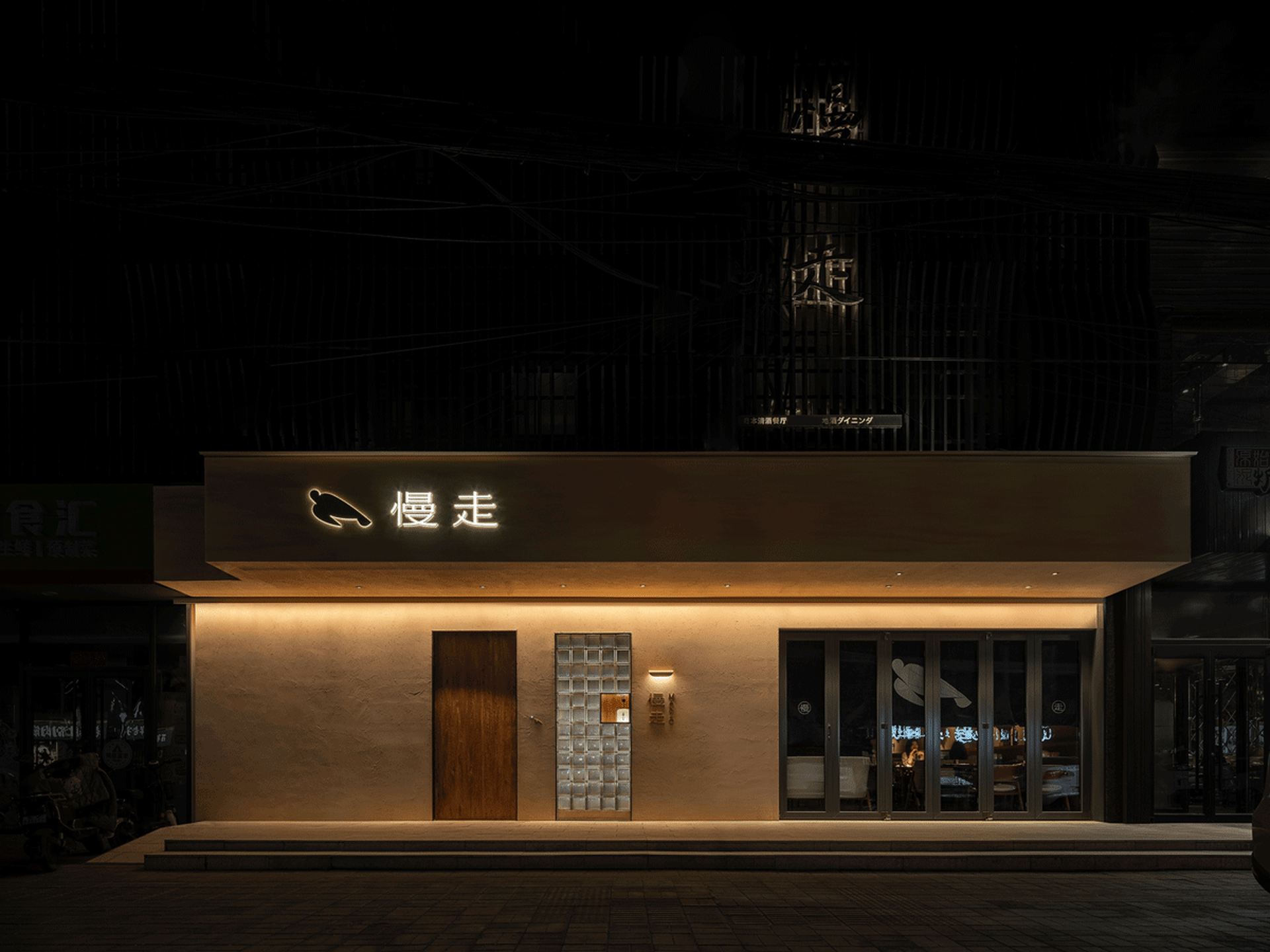 夜晚的現代餐廳,混凝土外牆,搭配中文招牌。