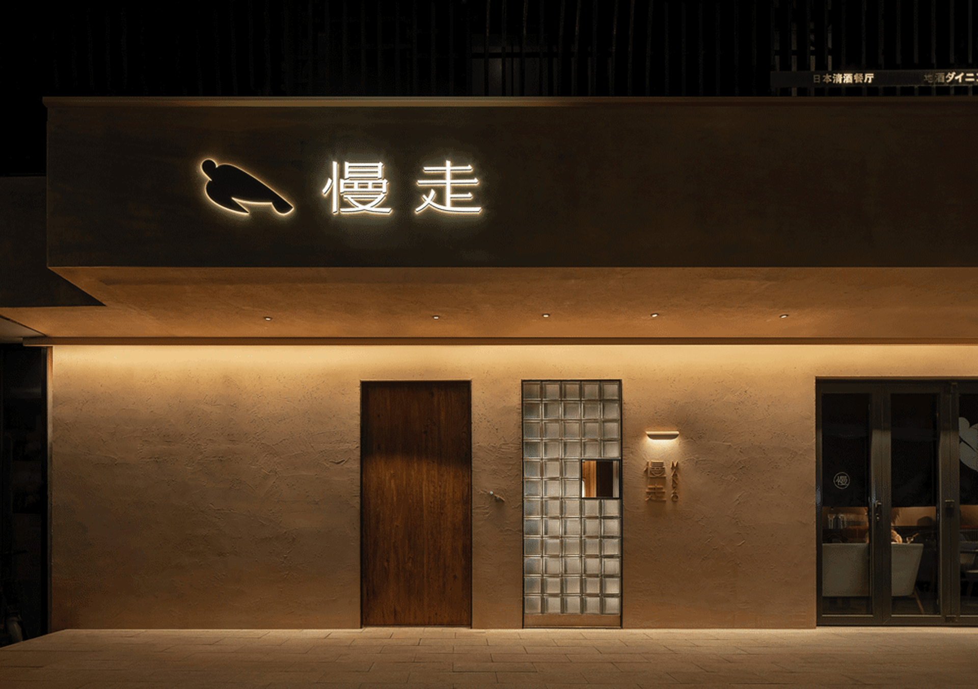 Modern restaurant exterior with concrete and glass materials.