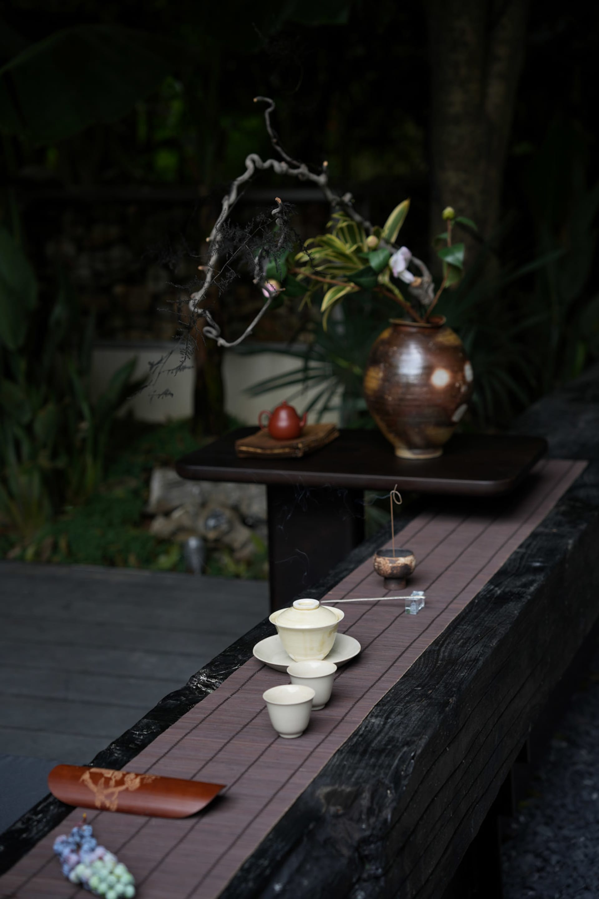 A rustic tea ceremony setup featuring wooden surfaces and ceramic elements.