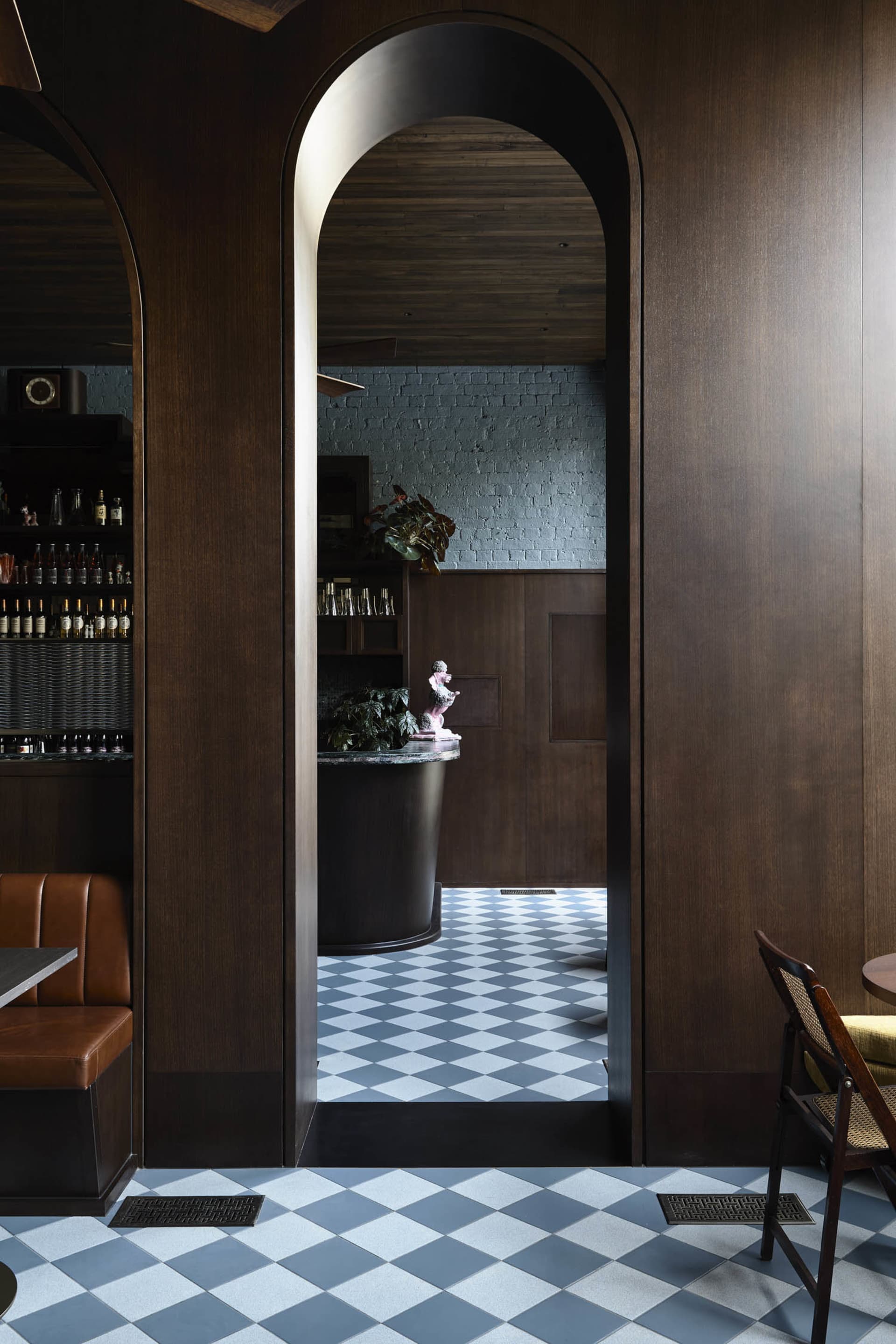 A modern industrial restaurant interior with wooden walls, concrete flooring, and marble tiles.