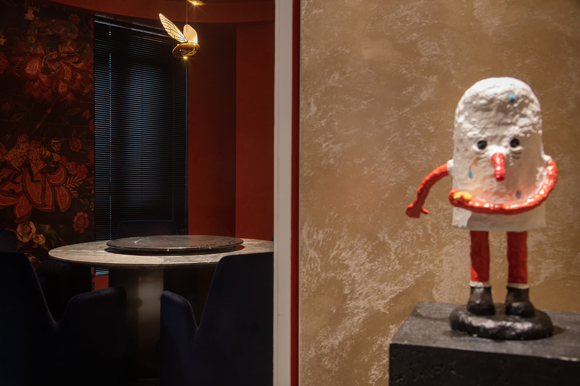 A modern interior design featuring metal, fabric, concrete, and glass elements.