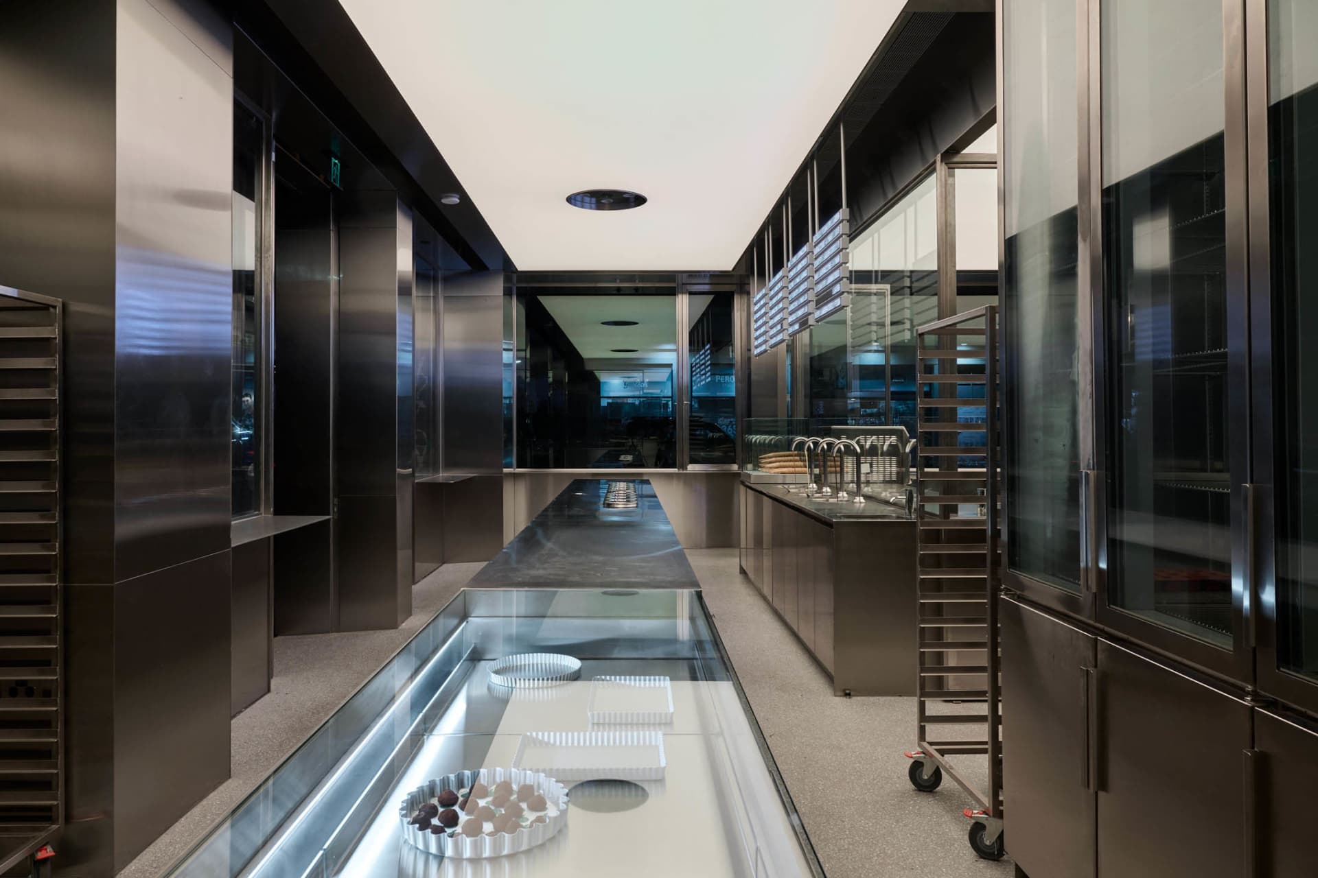A modern, industrial commercial kitchen featuring steel surfaces and minimalist design.