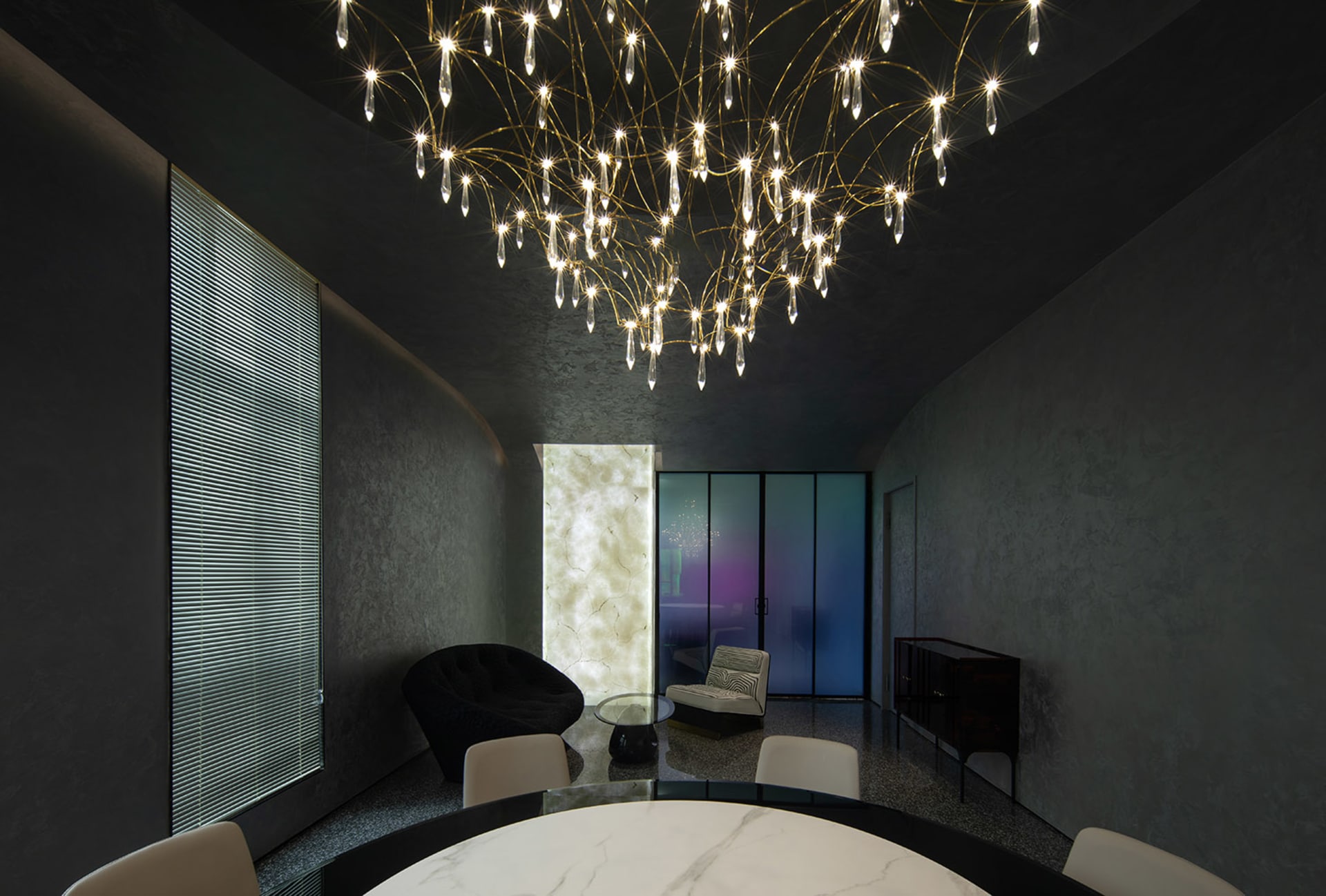 Modern dining room featuring metal, glass, and marble materials.