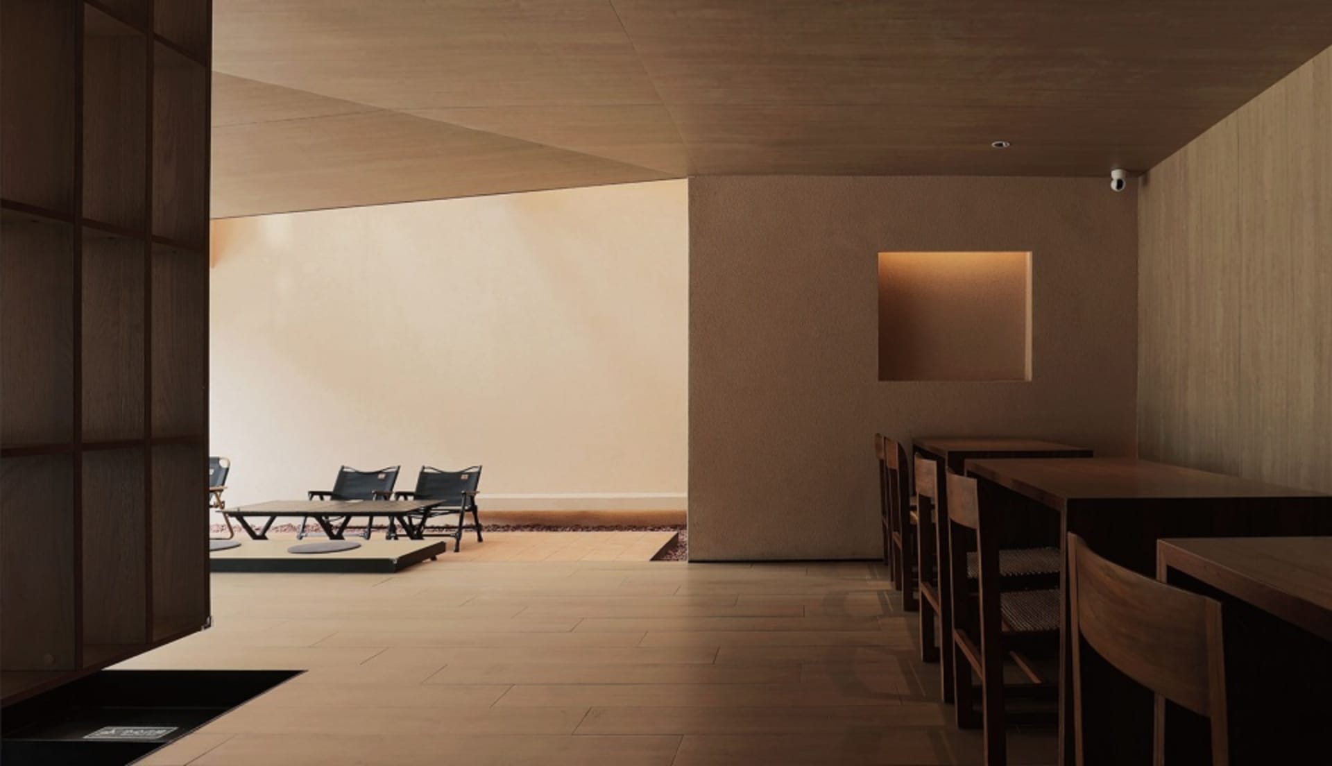 A minimalist restaurant interior with wooden tables and chairs