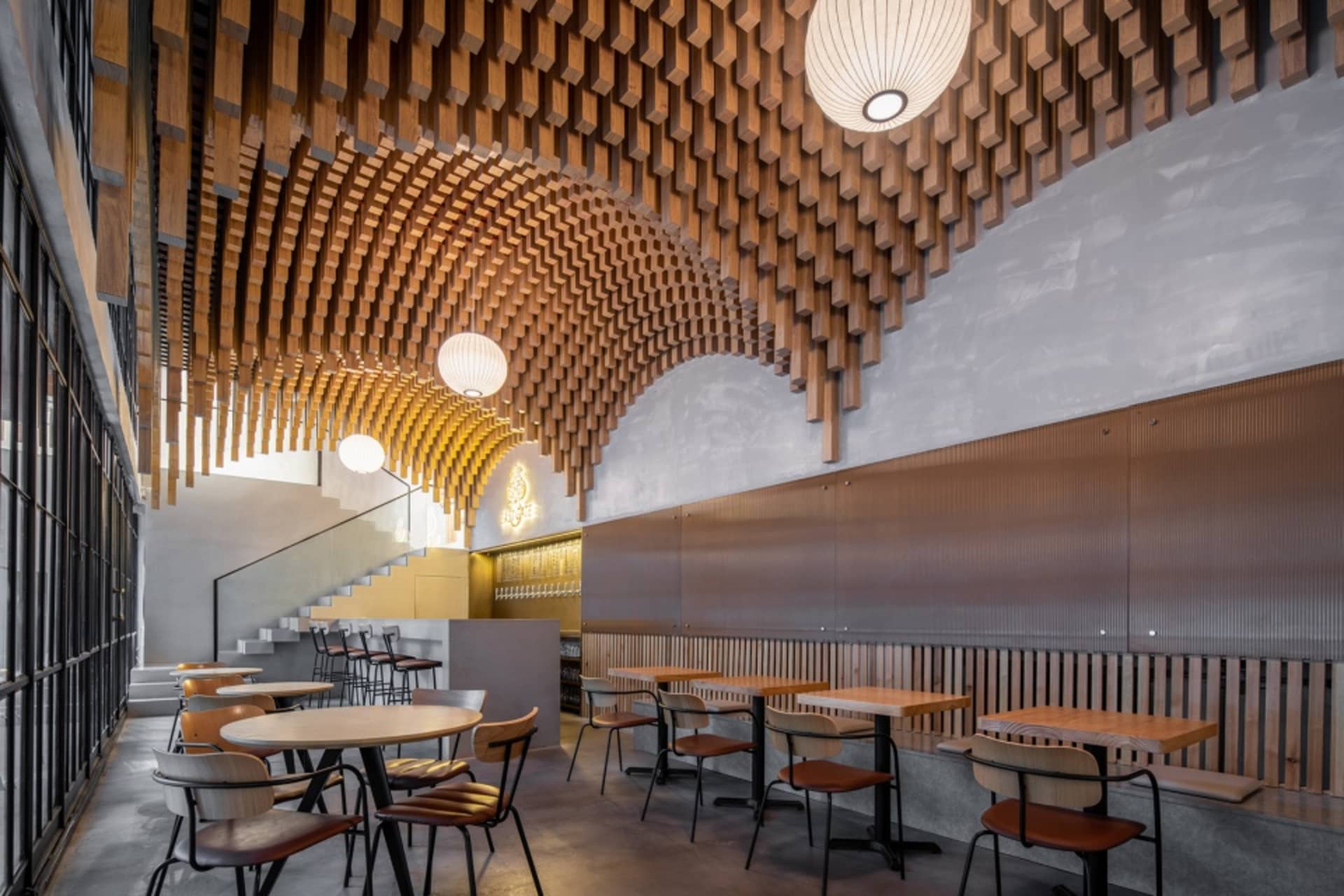 Industrial-style restaurant interior featuring a wooden ceiling and modern furniture.