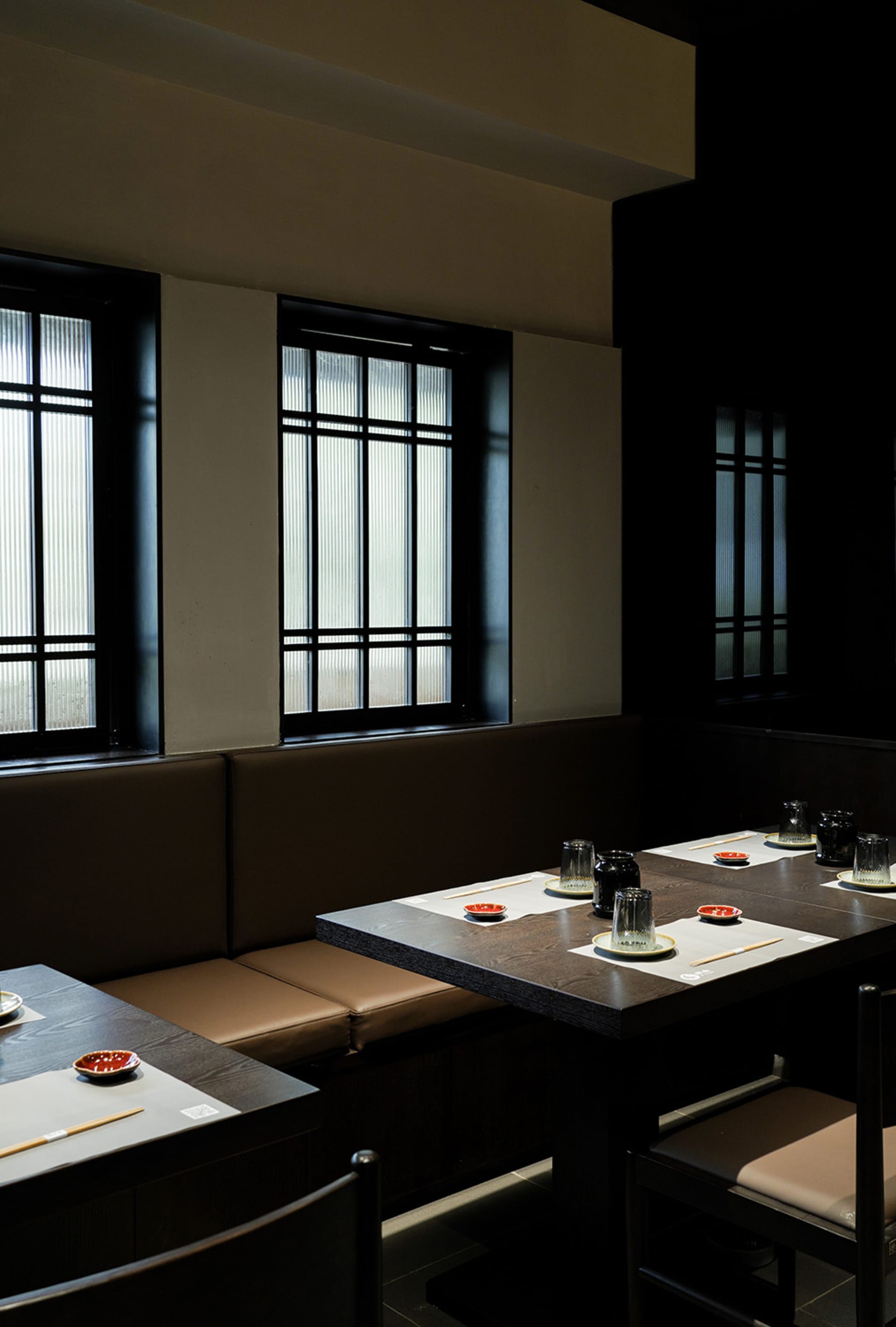 Modern restaurant interior featuring wooden tables and seating arrangements.