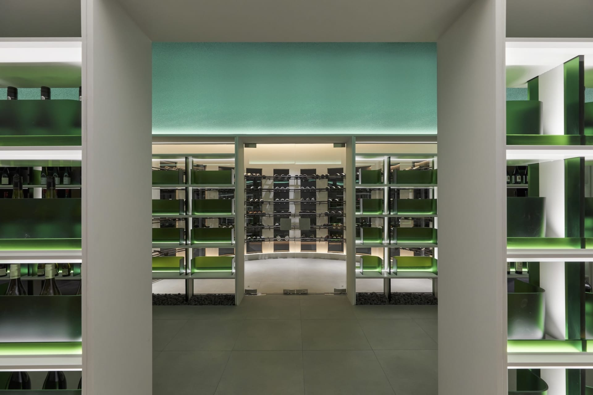 Modern interior design of a wine shop featuring glass-enclosed shelves.