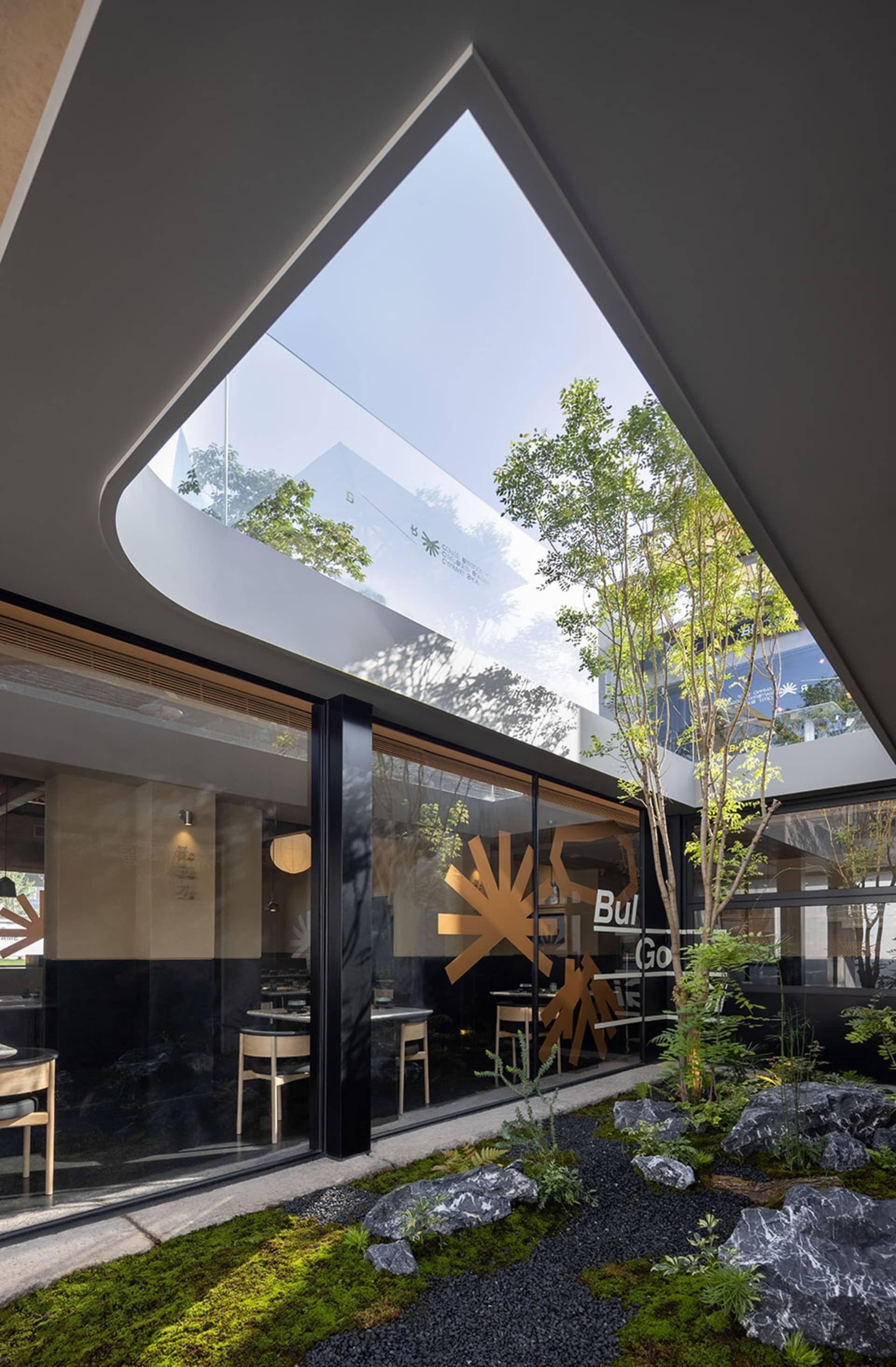現代餐廳室內空間,採用玻璃牆與混凝土元素。