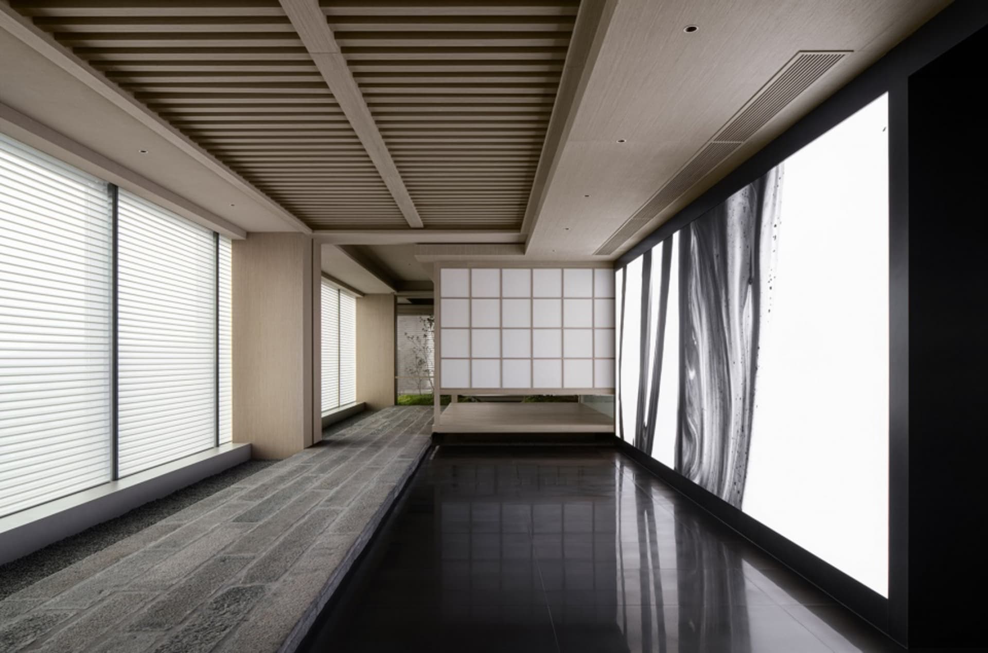 Modern interior design featuring a glass panel with abstract black and white image in a hotel lobby.