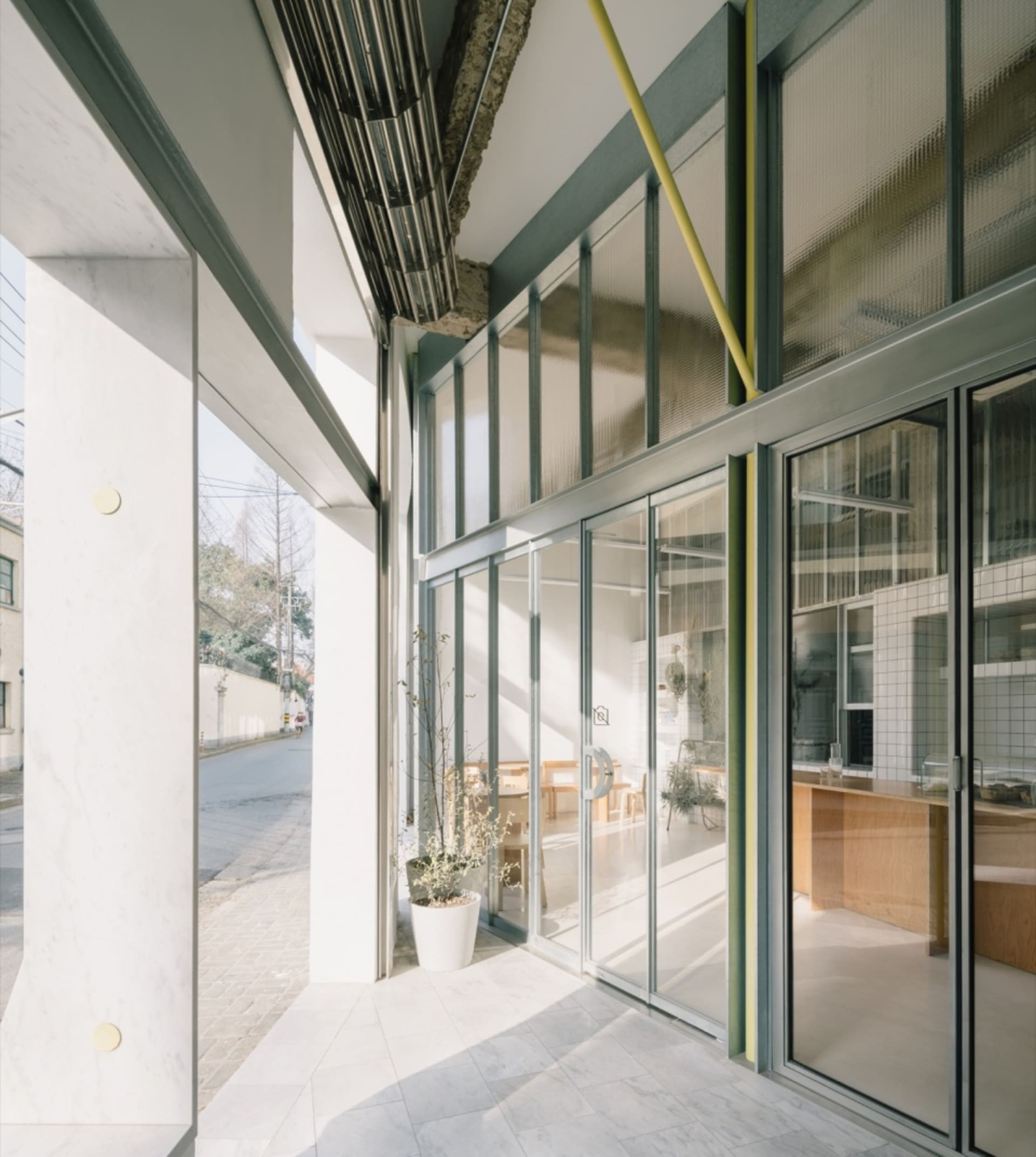 Modern industrial storefront with concrete, glass, and steel materials.