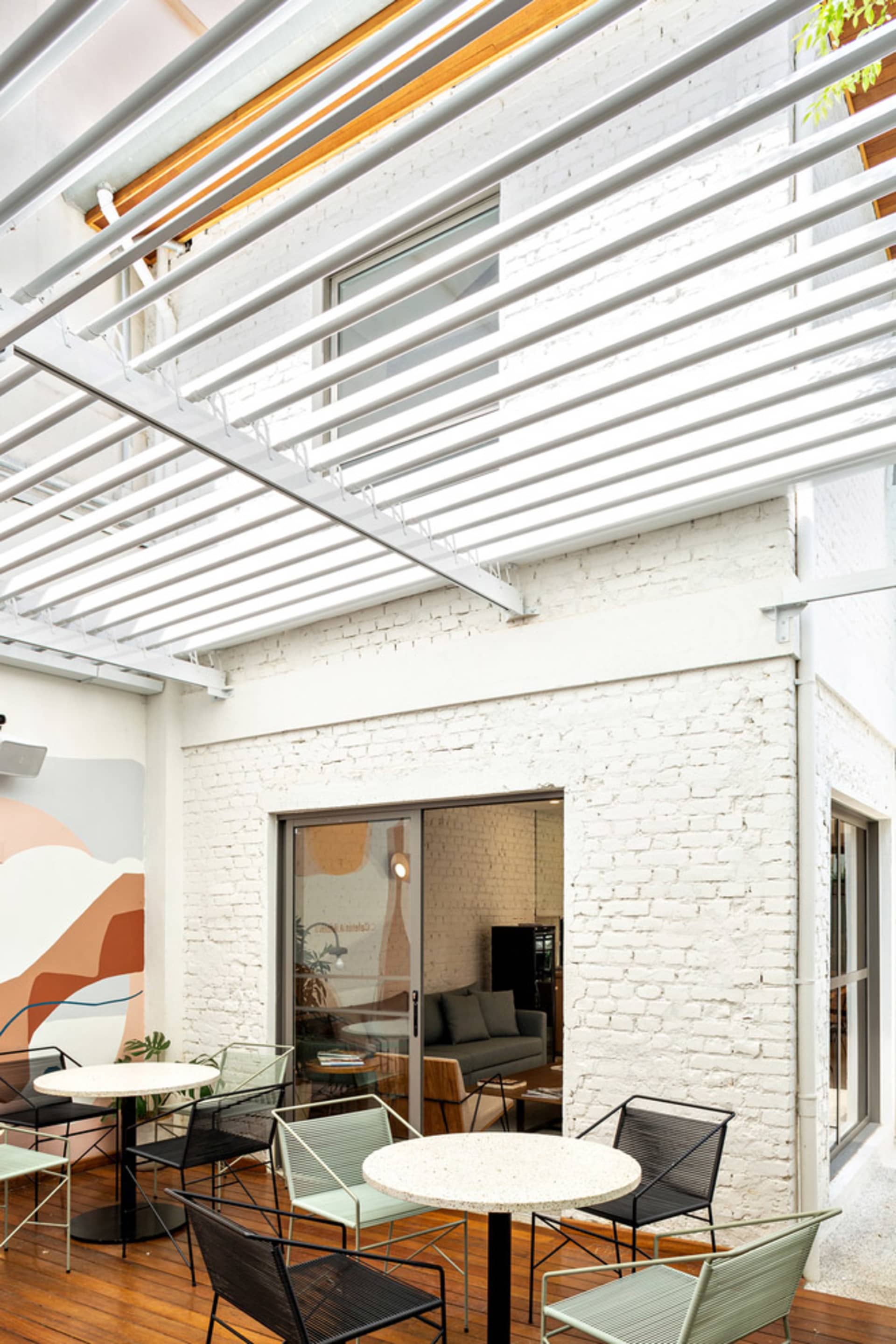 Modern minimalist terrace with white brick walls, concrete flooring, and outdoor seating area.