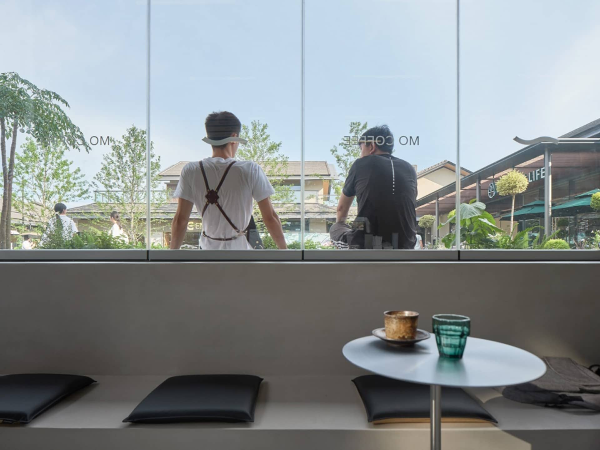 現代咖啡廳室內，擁有大型玻璃窗，可俯瞰街道與窗外綠意。