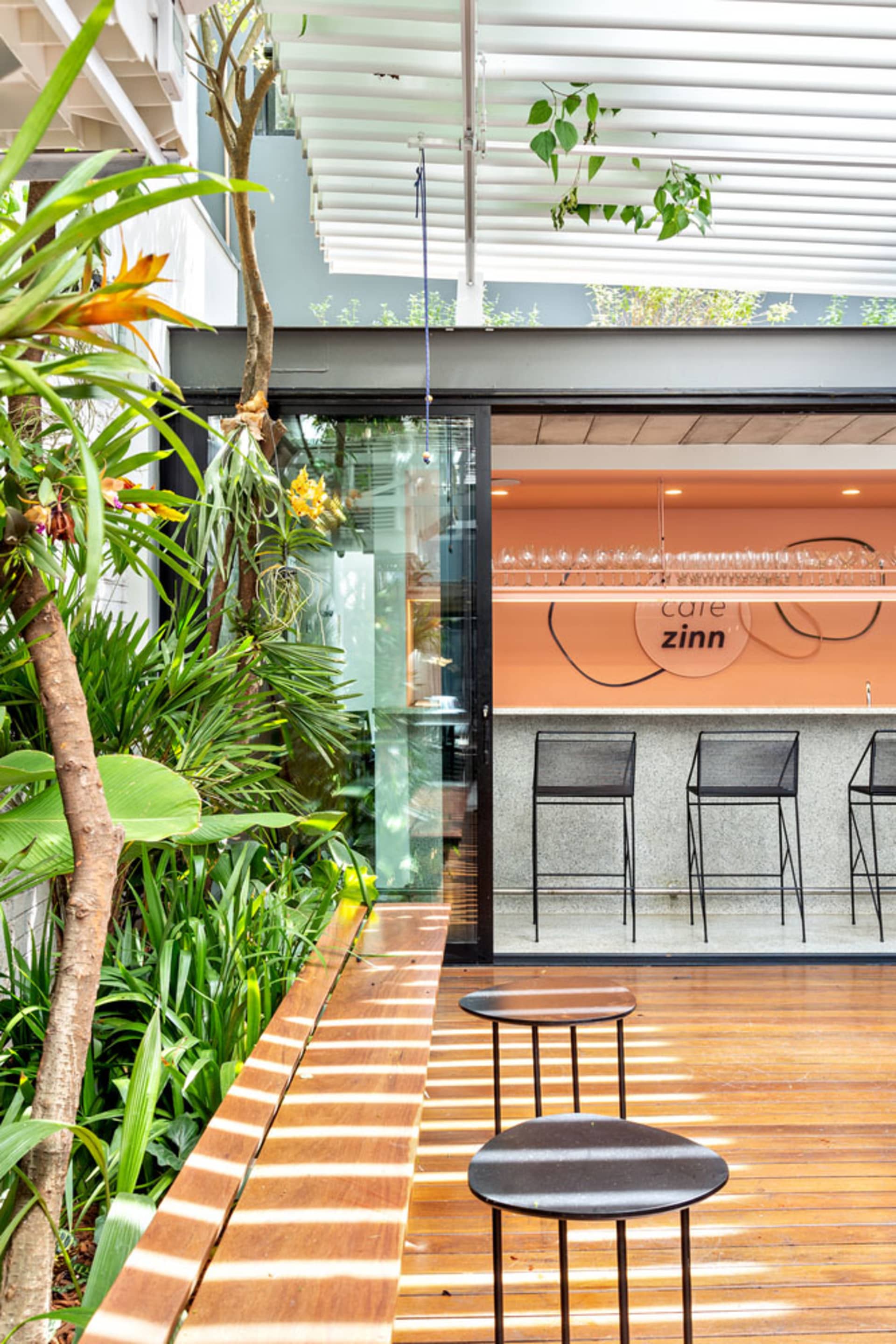 Modern cafe interior with mixed materials and greenery.
