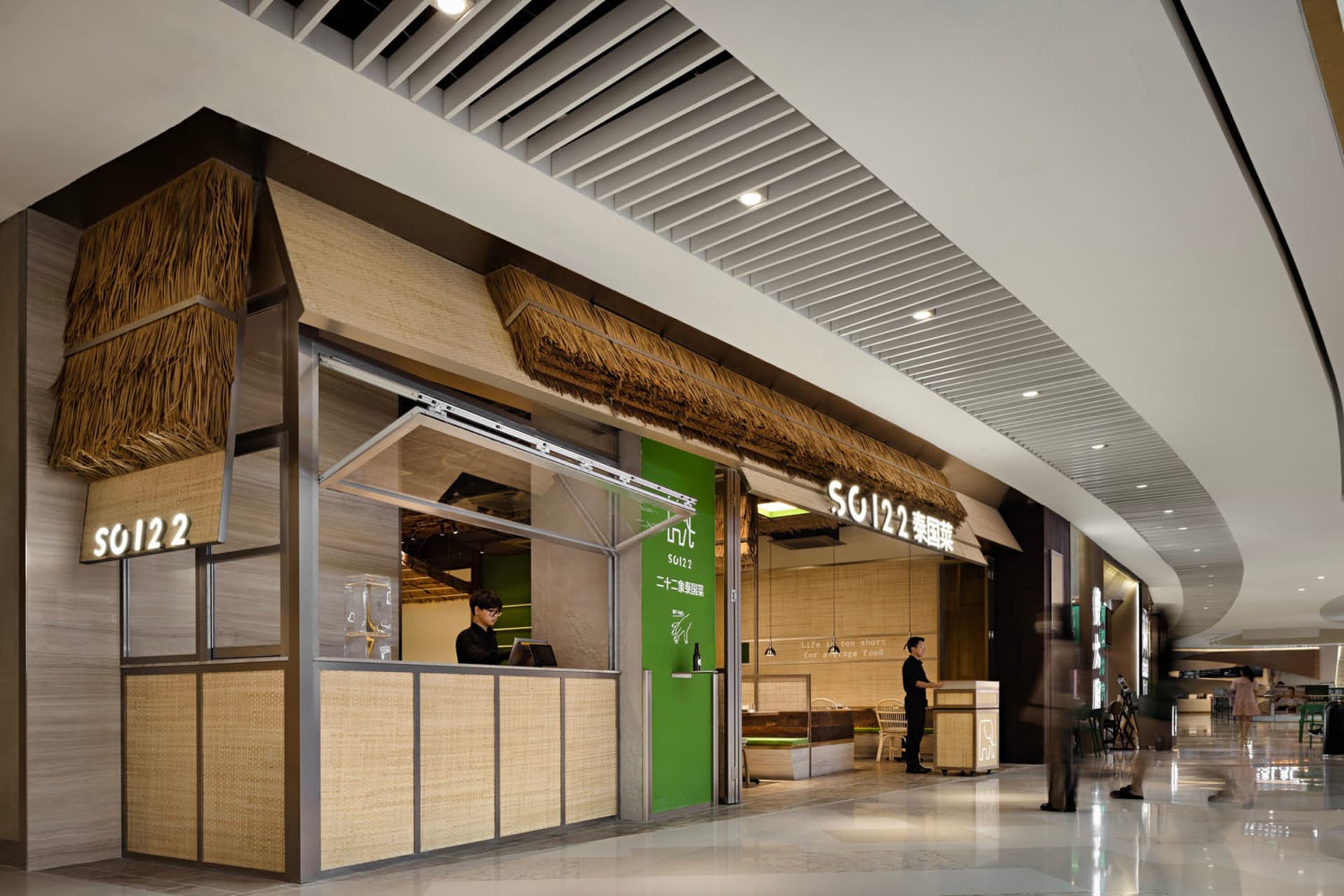A minimalist restaurant interior featuring bamboo elements and green accents.