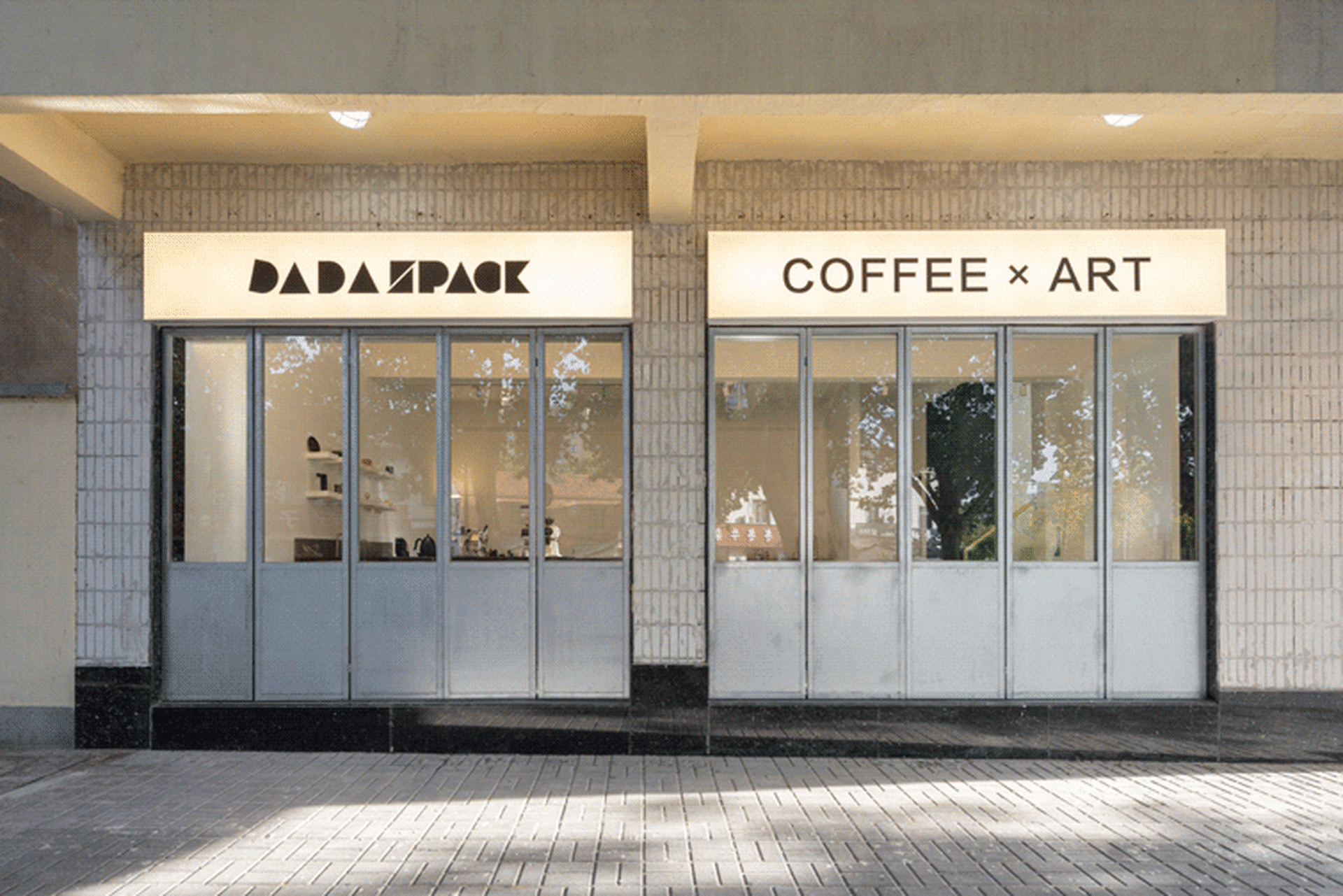 現代咖啡店的外觀，擁有玻璃店面，上面印有「BADAZPACK」與「COFFEE × ART」文字。