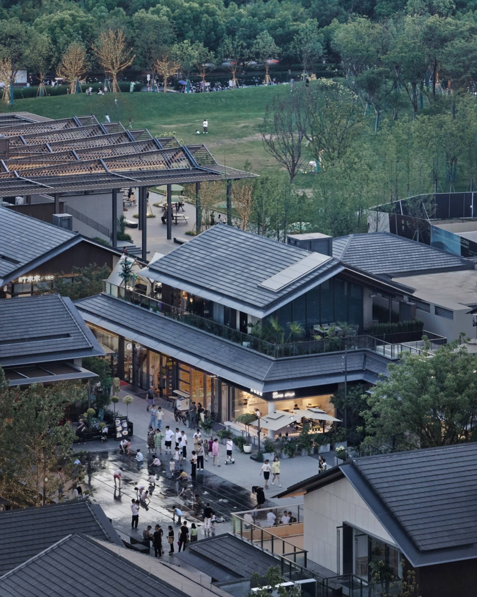 Urban landscape scene featuring modern glass and concrete buildings surrounded by greenery.