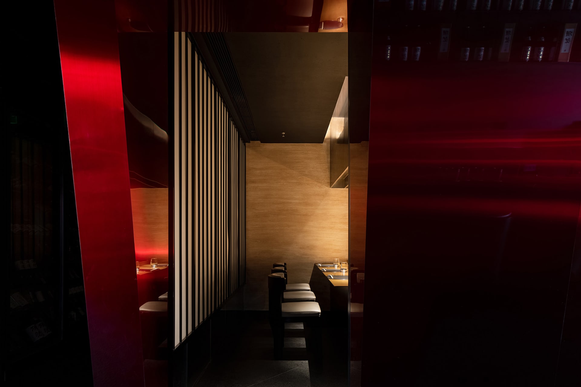 A dimly lit restaurant interior with wooden walls and seating arrangements.