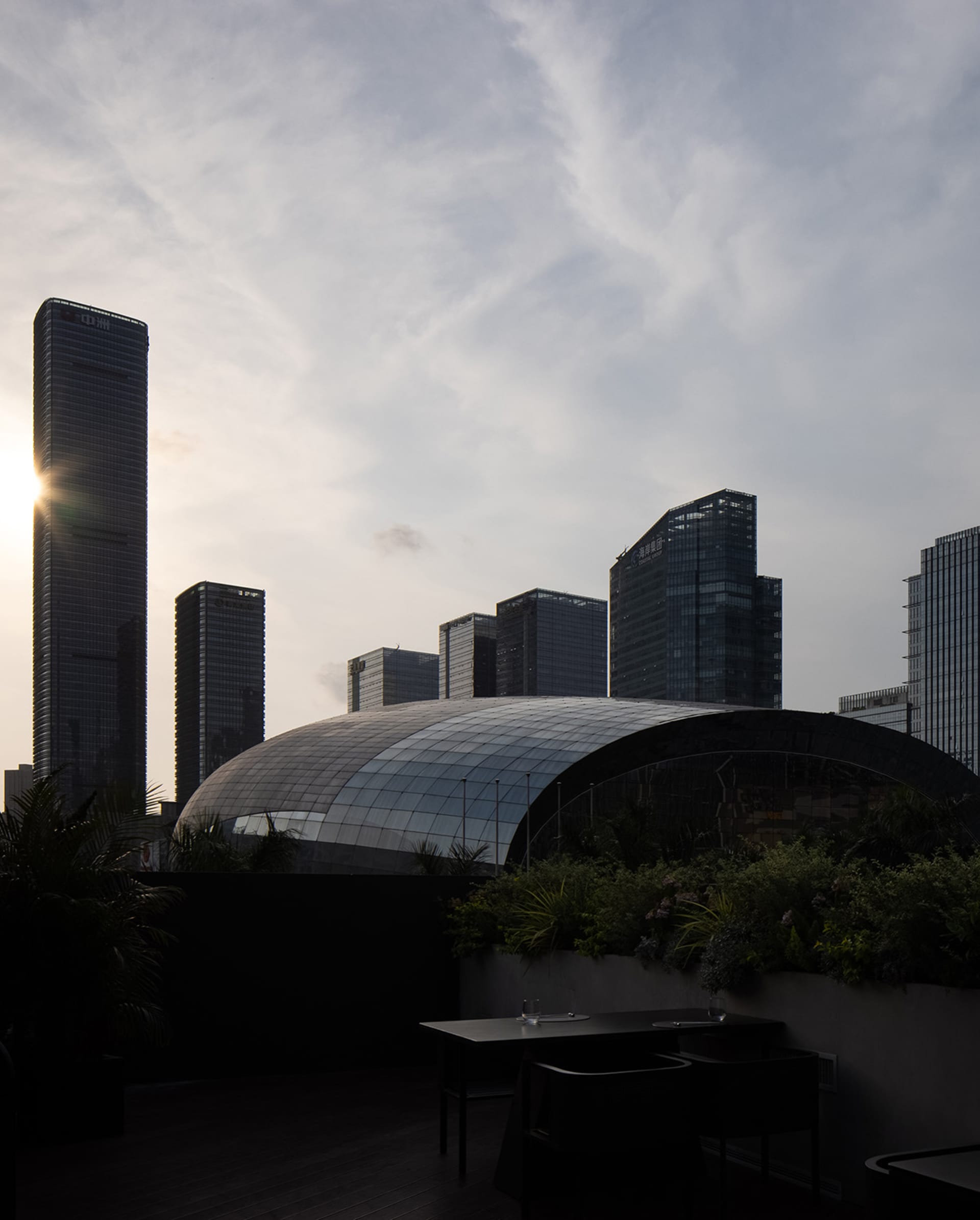 一座玻璃覆面的建築物在城市景觀背景下顯眼矗立。