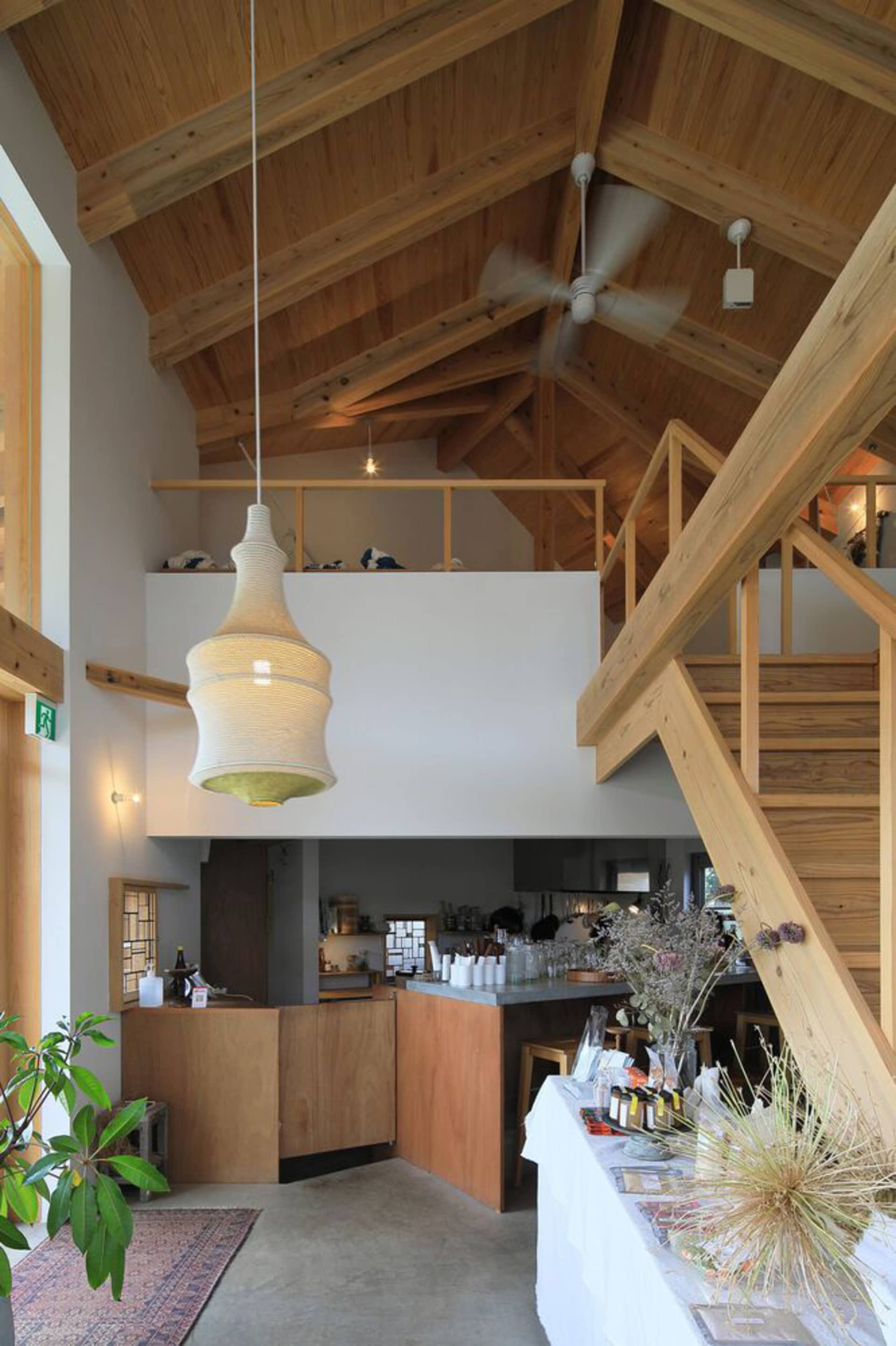 An industrial-style cafe featuring concrete flooring, wooden beams, and a loft interior.