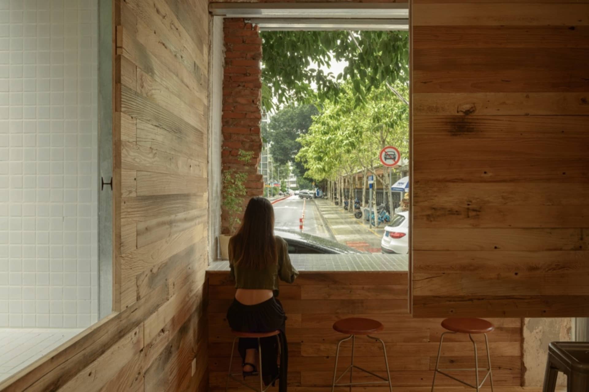 A modern design featuring window seating in a coffee shop with wood and brick materials.
