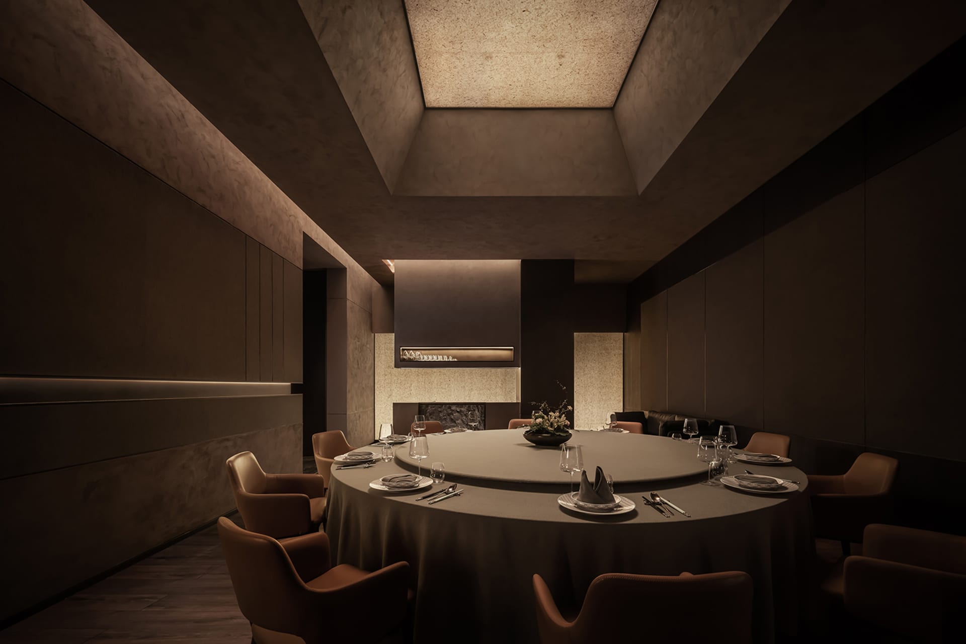 Modern restaurant interior with circular table, chairs, and concrete walls and ceiling.