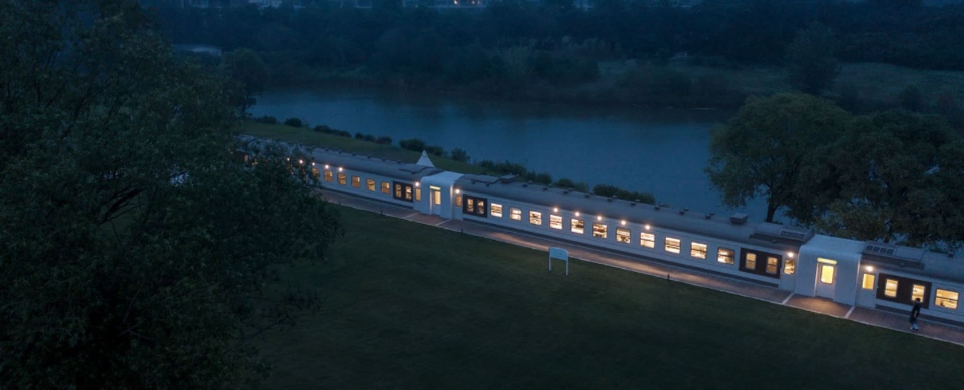 A modern train with a sleek design and illuminated windows.