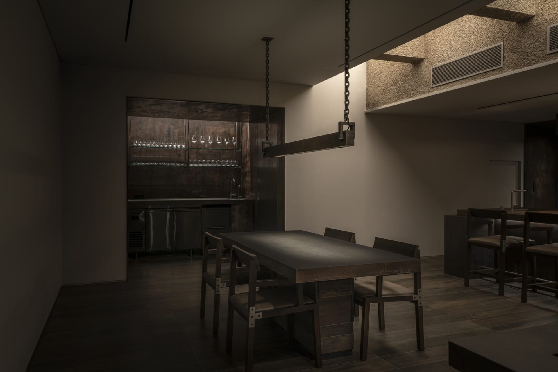 工業風餐廳內部,餐區擺放木質餐桌與金屬椅,搭配簡約裝飾與燈光