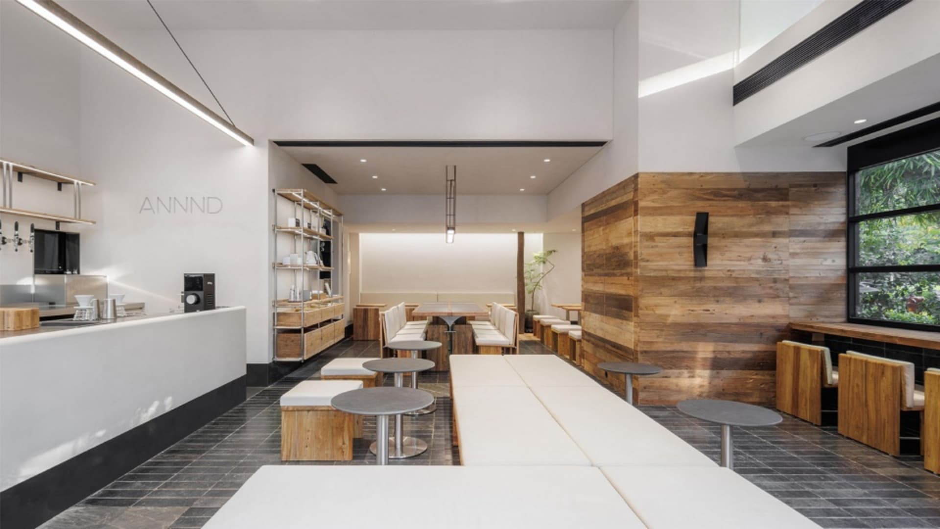Interior of a modern cafe with wooden walls and white seating areas