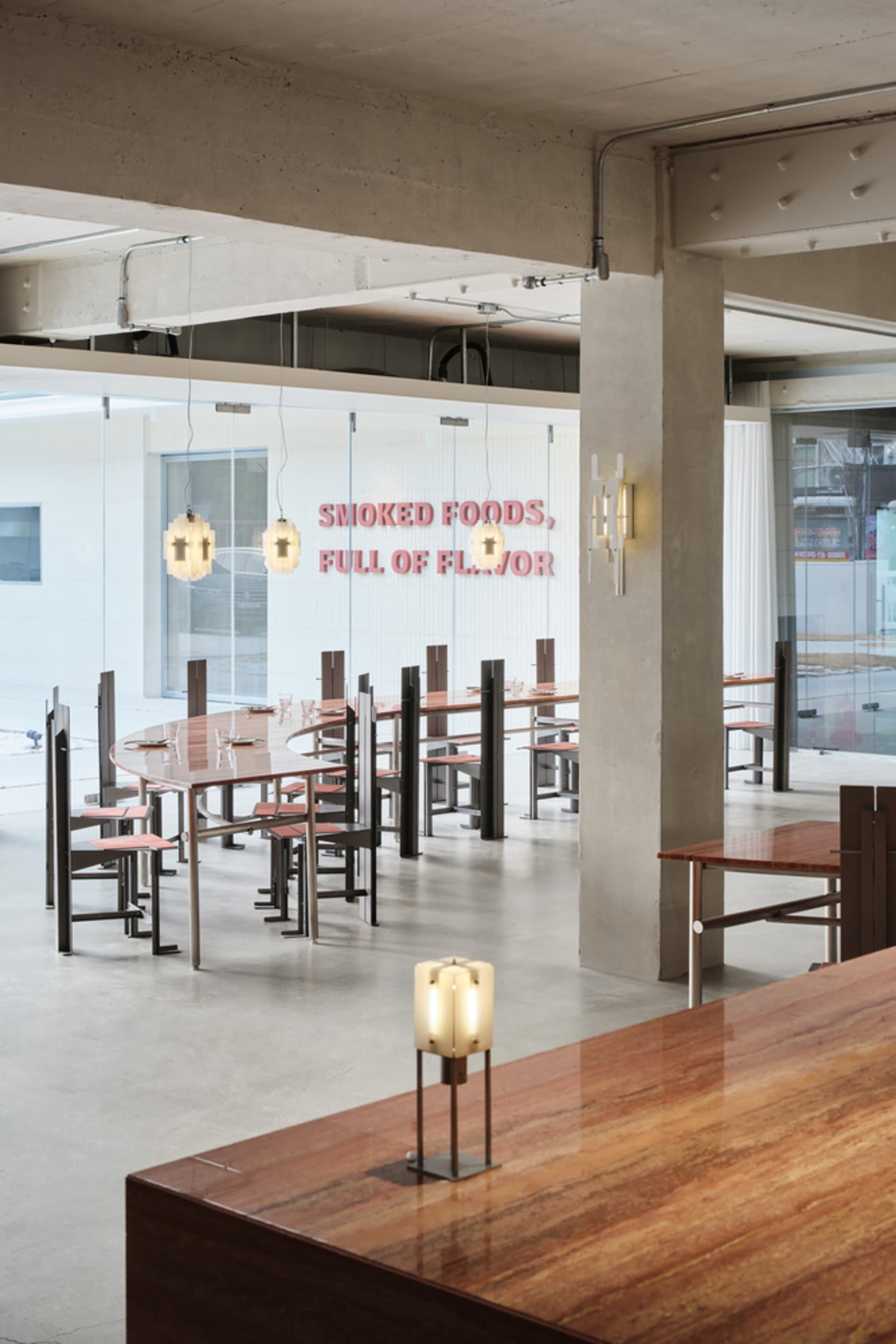 A modern restaurant interior with a concrete floor and minimalist decor.