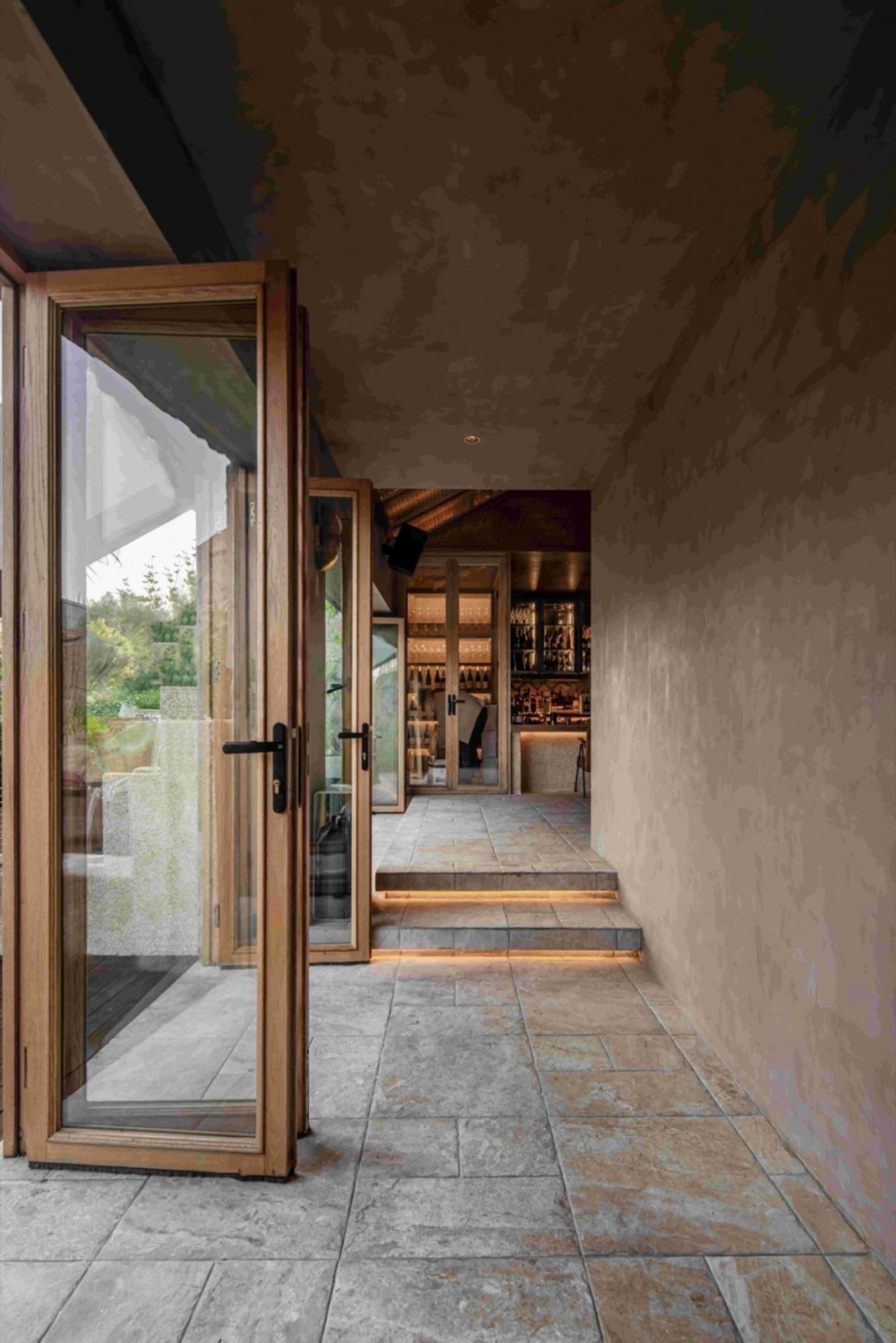 A minimalist restaurant interior with stone and wood elements, showcasing modern design and natural materials.