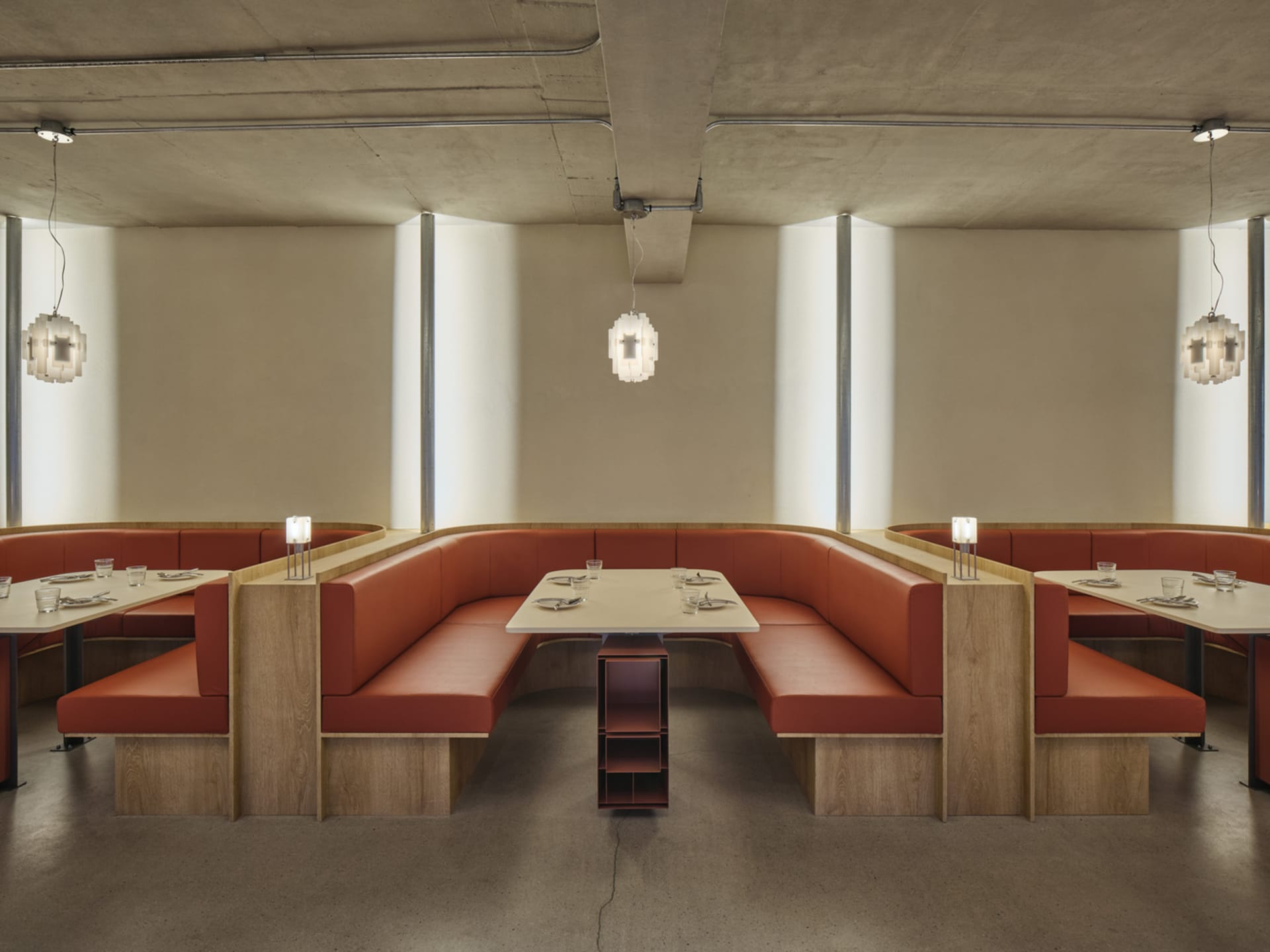 Modern restaurant interior with booth seating made of leather on concrete floor