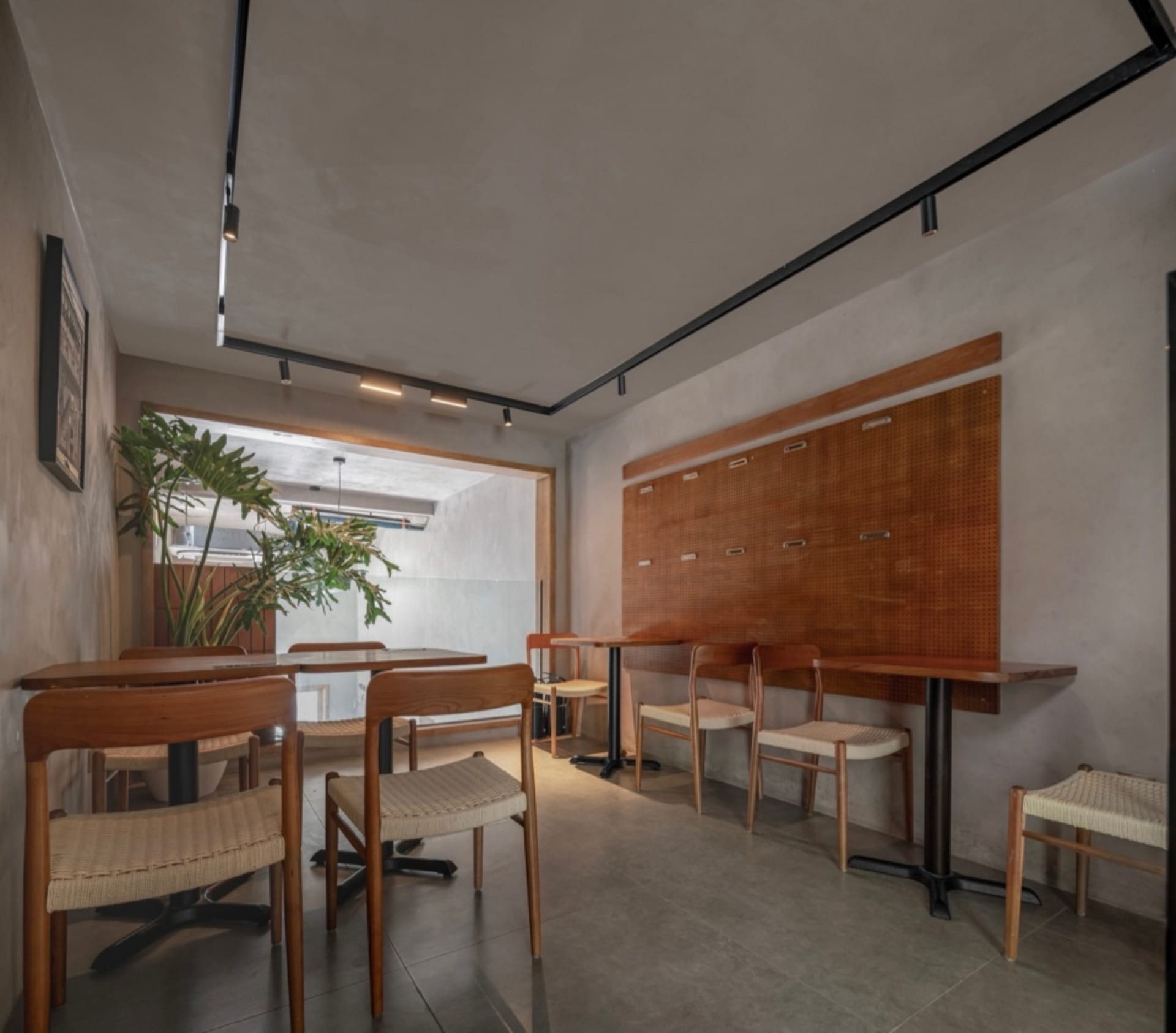 An industrial-style cafe interior featuring wooden furniture and concrete flooring.