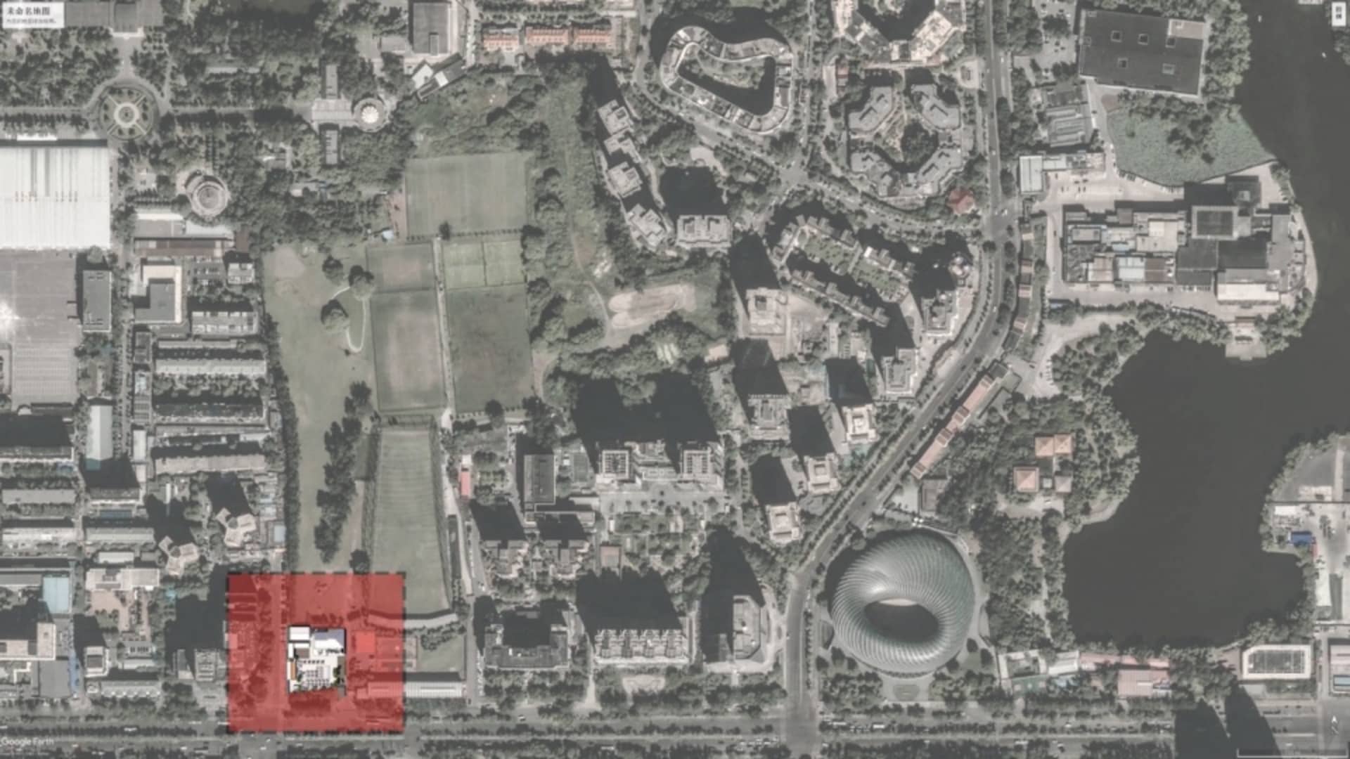 Aerial view of a city with various buildings, parks, and roads.