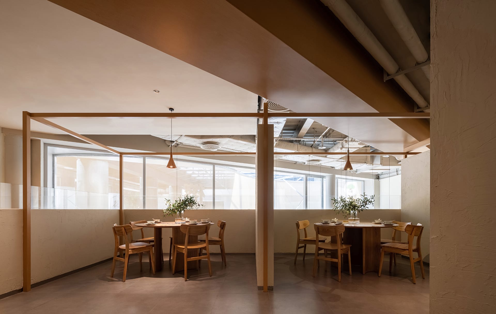 Industrial-style restaurant interior with wooden tables, glass sliding walls, and metal pipes