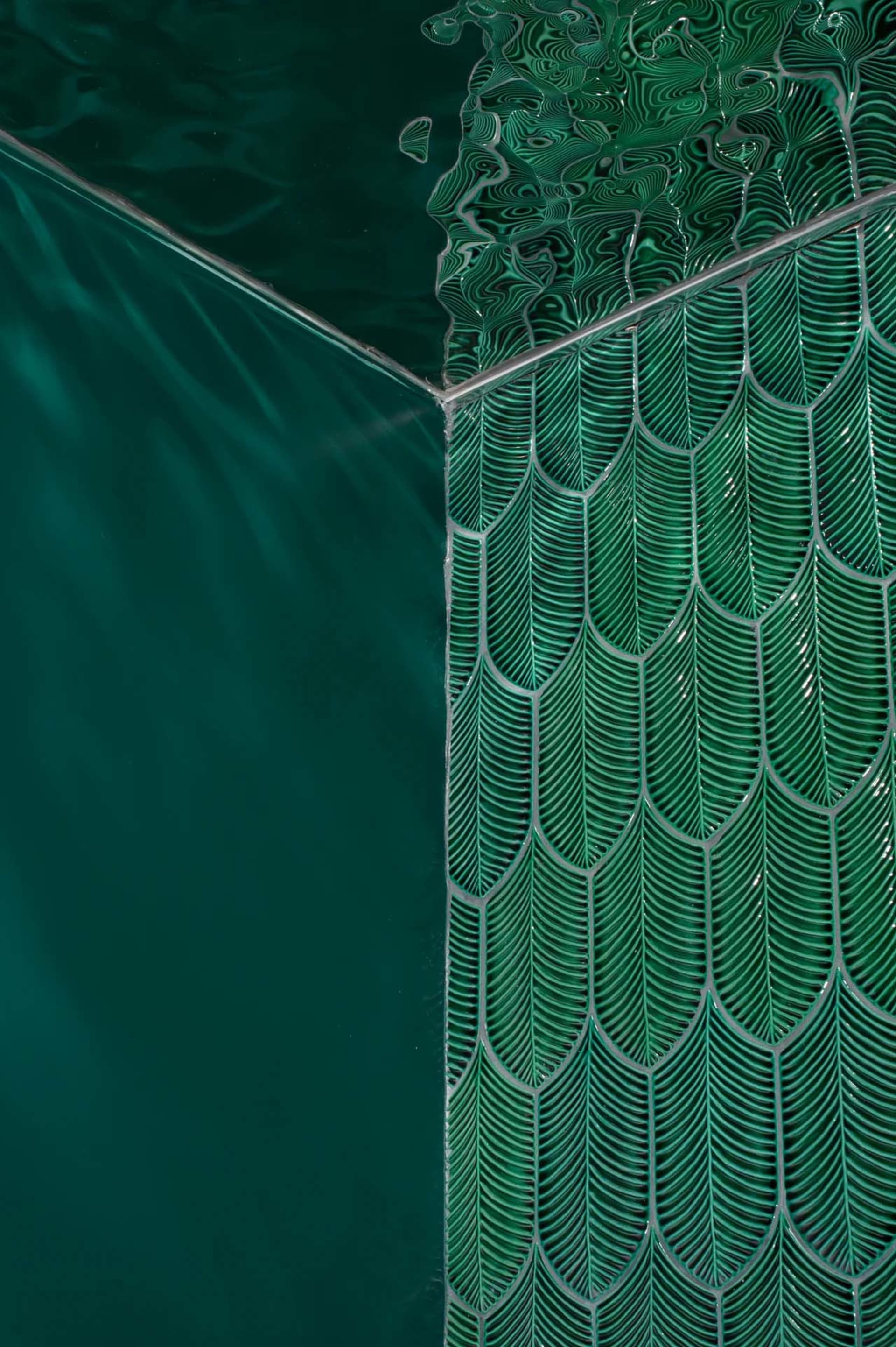 A close-up view of green scallop-patterned glass tiles