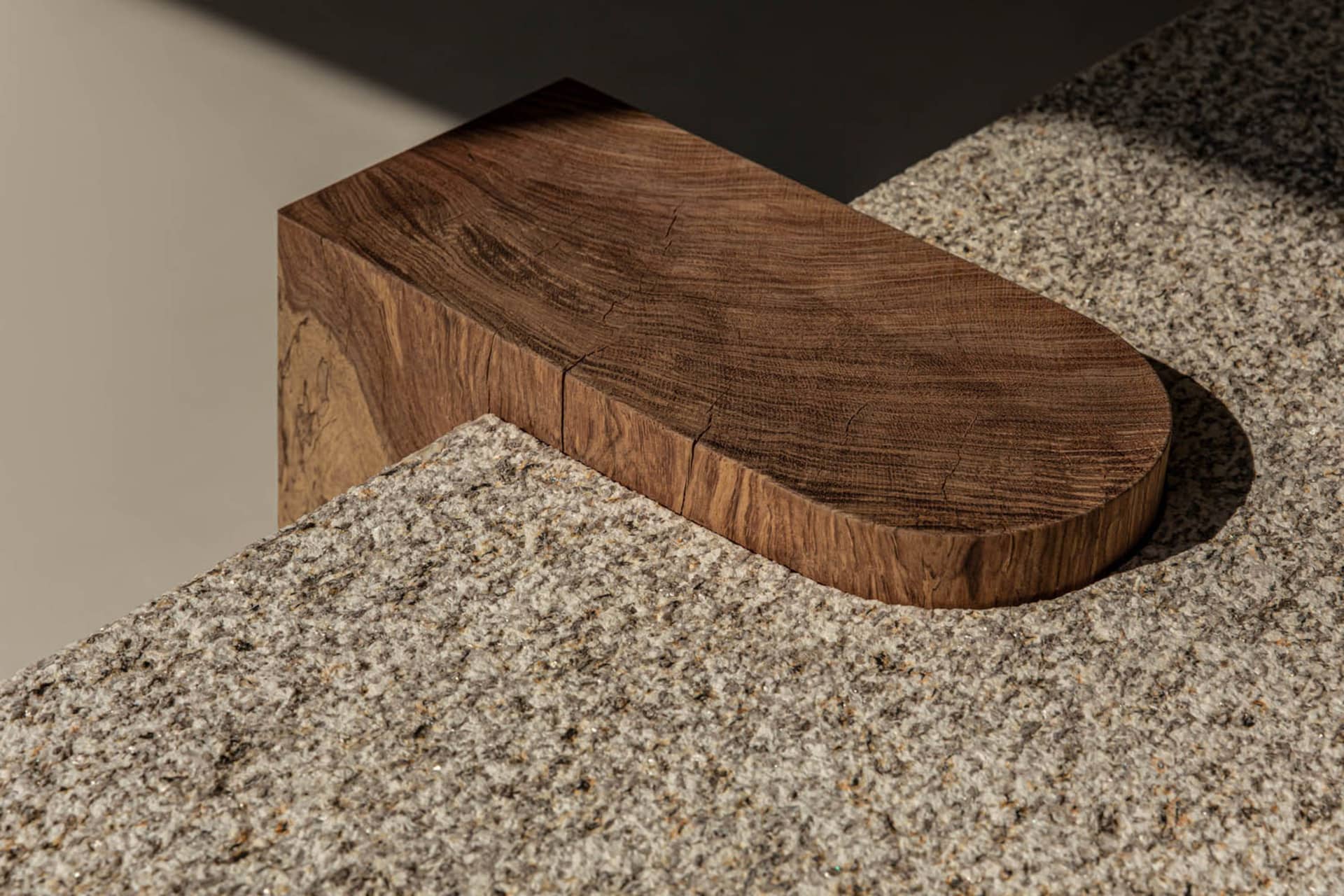 A wooden block with a textured surface placed on a grey, speckled surface.
