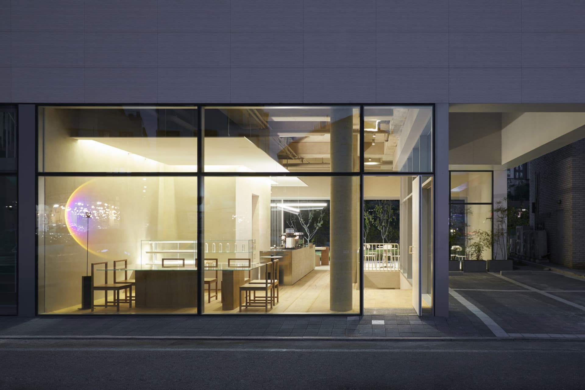 A modern retail storefront with glass windows and seating area.