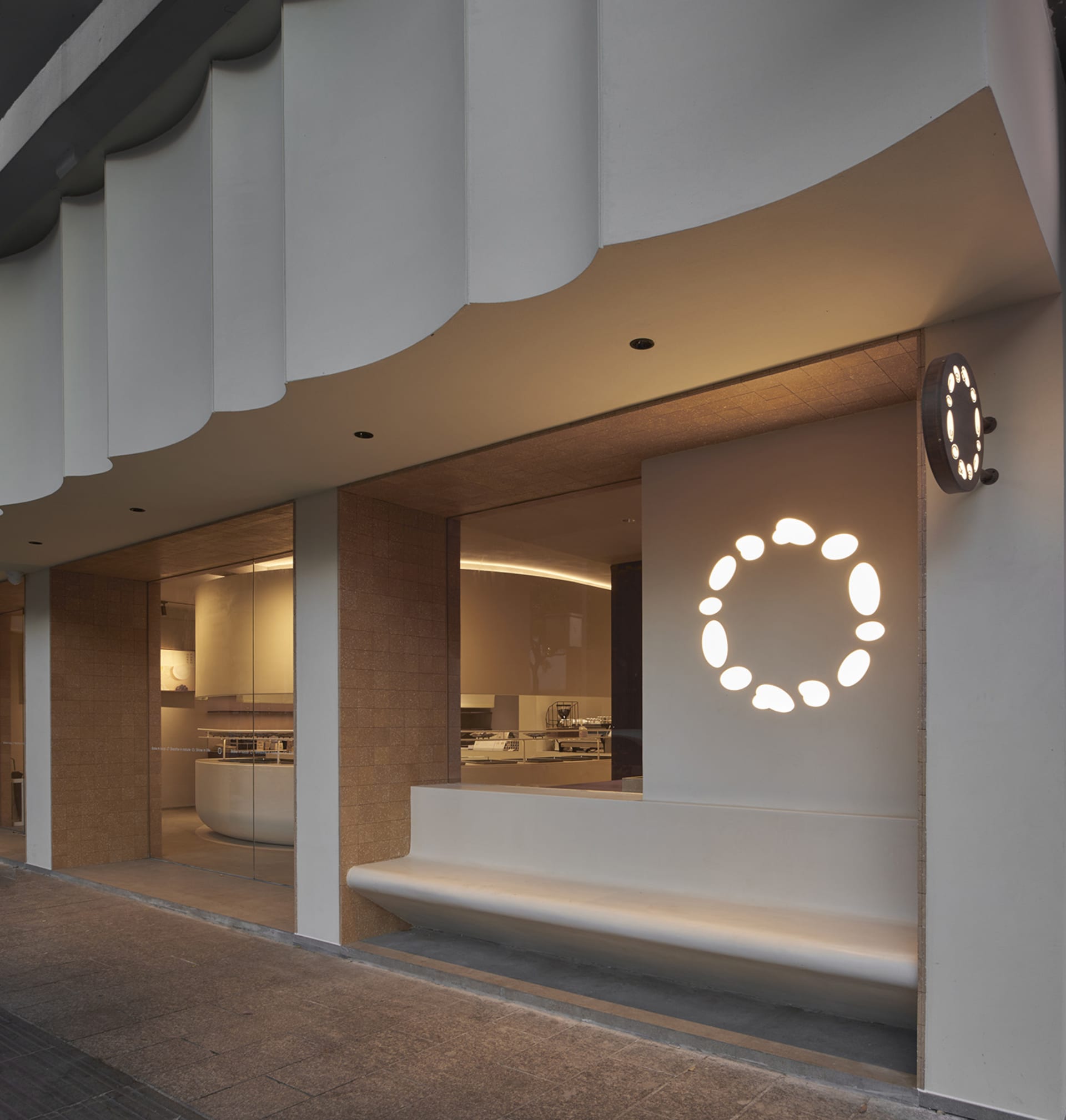 A modern retail storefront with a white circular light feature in the window.