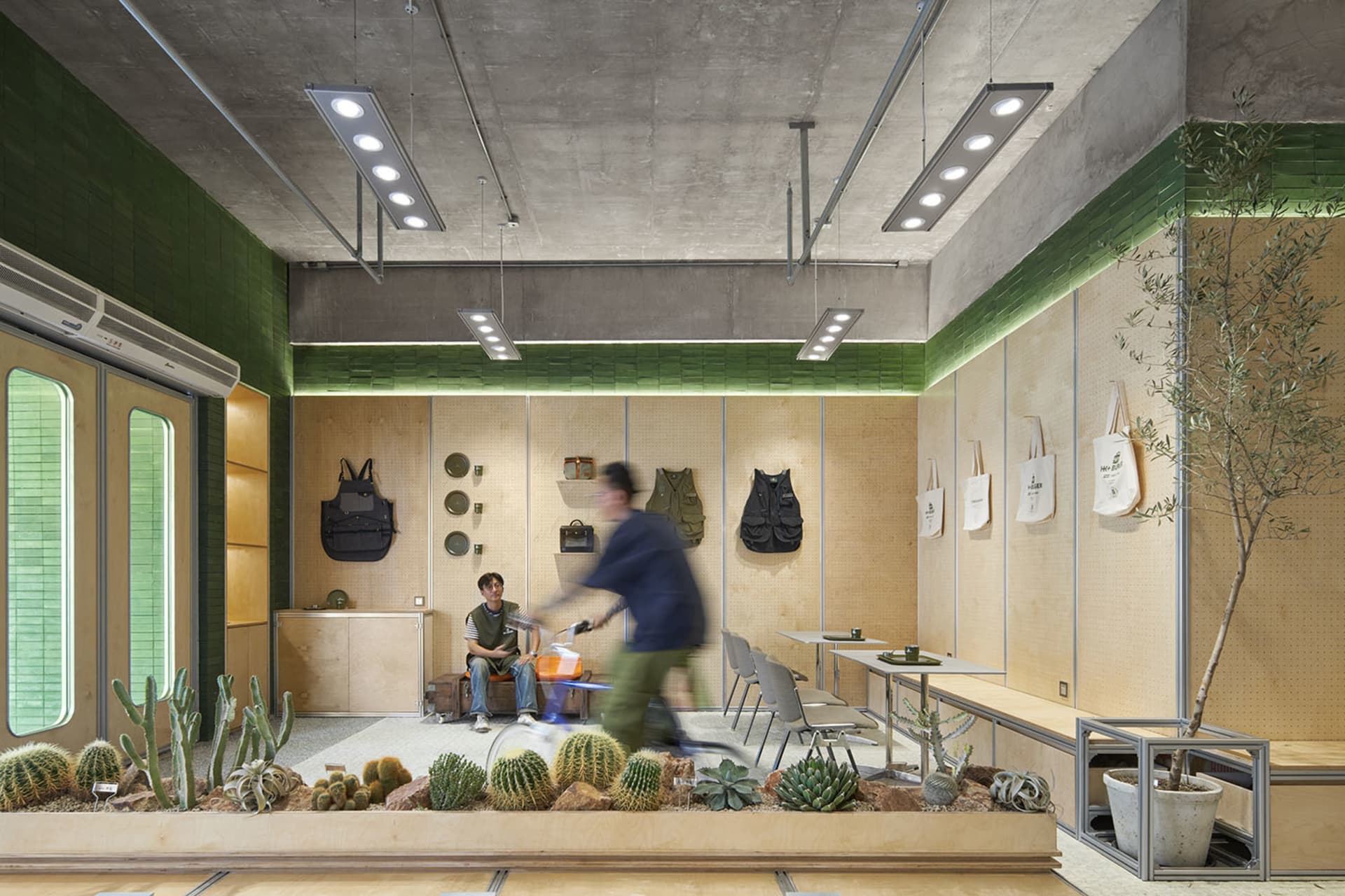 A modern industrial-style coffee shop with concrete, wood, and metal elements.