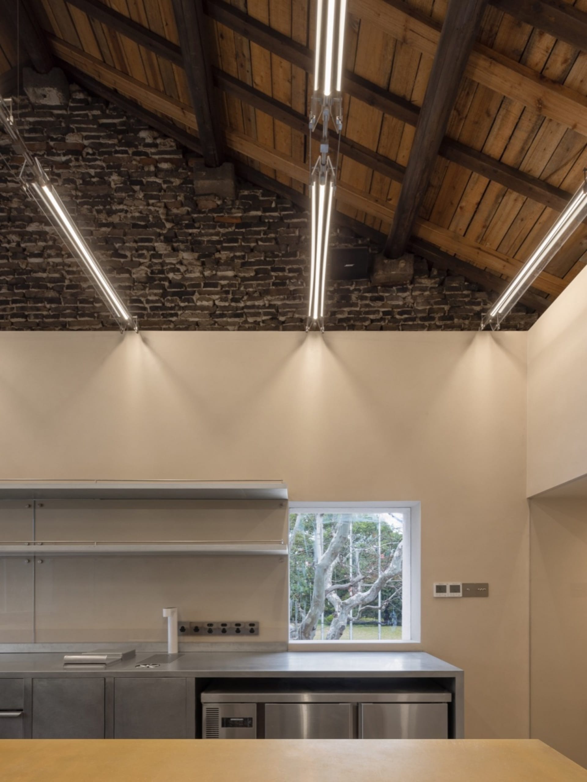 An industrial-style kitchen featuring metal countertops and wooden accents.