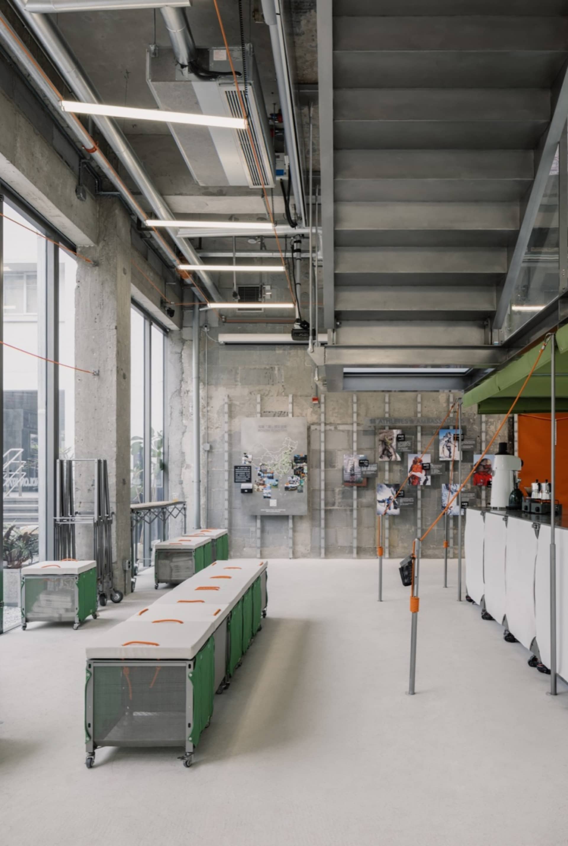 Industrial-style gymnasium with concrete walls, ceilings, and flooring, featuring minimalist design and exposed structural el