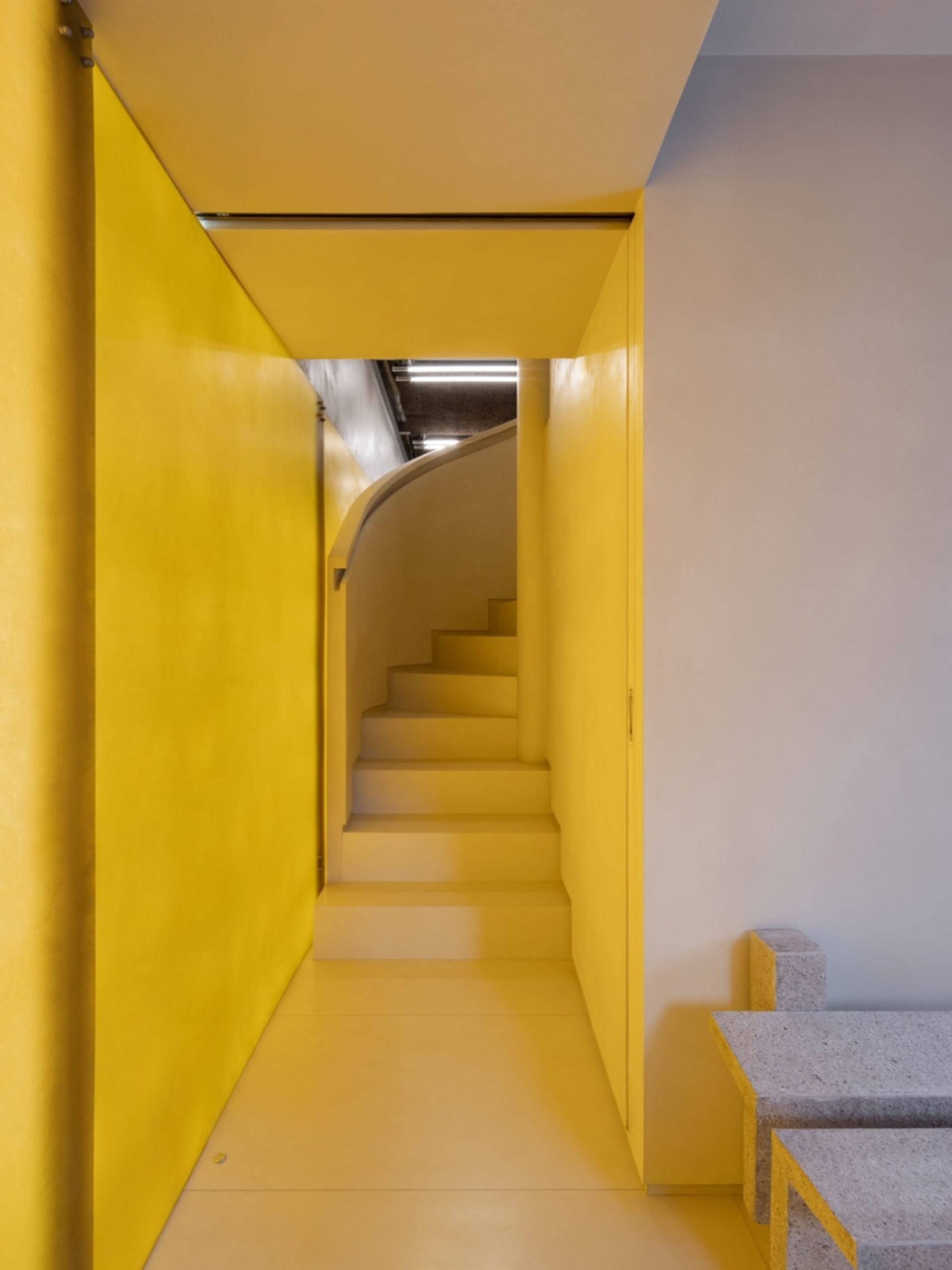 Modern concrete interior design with yellow accents and minimalist aesthetic