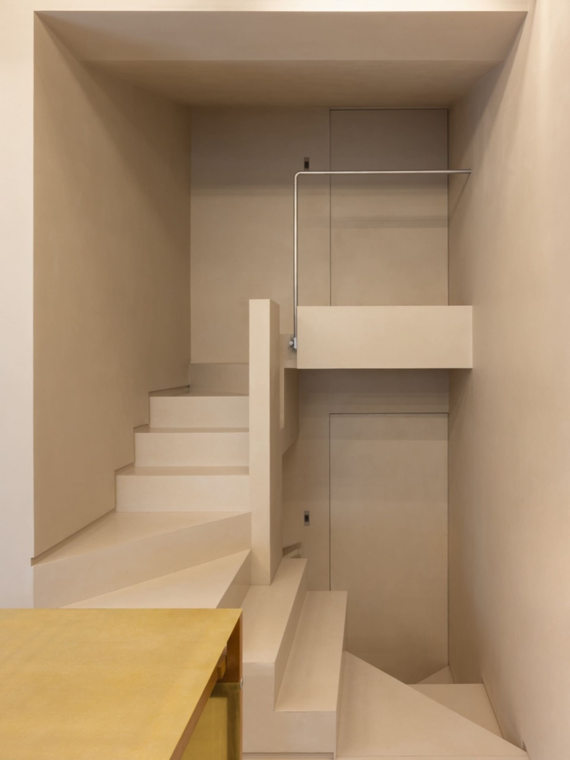 Minimalist modern interior featuring concrete stairs and metal railings.